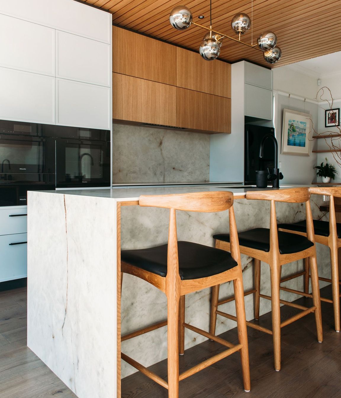 The porcelain benchtop has a waterfall end and ample overhang for the bar stools.