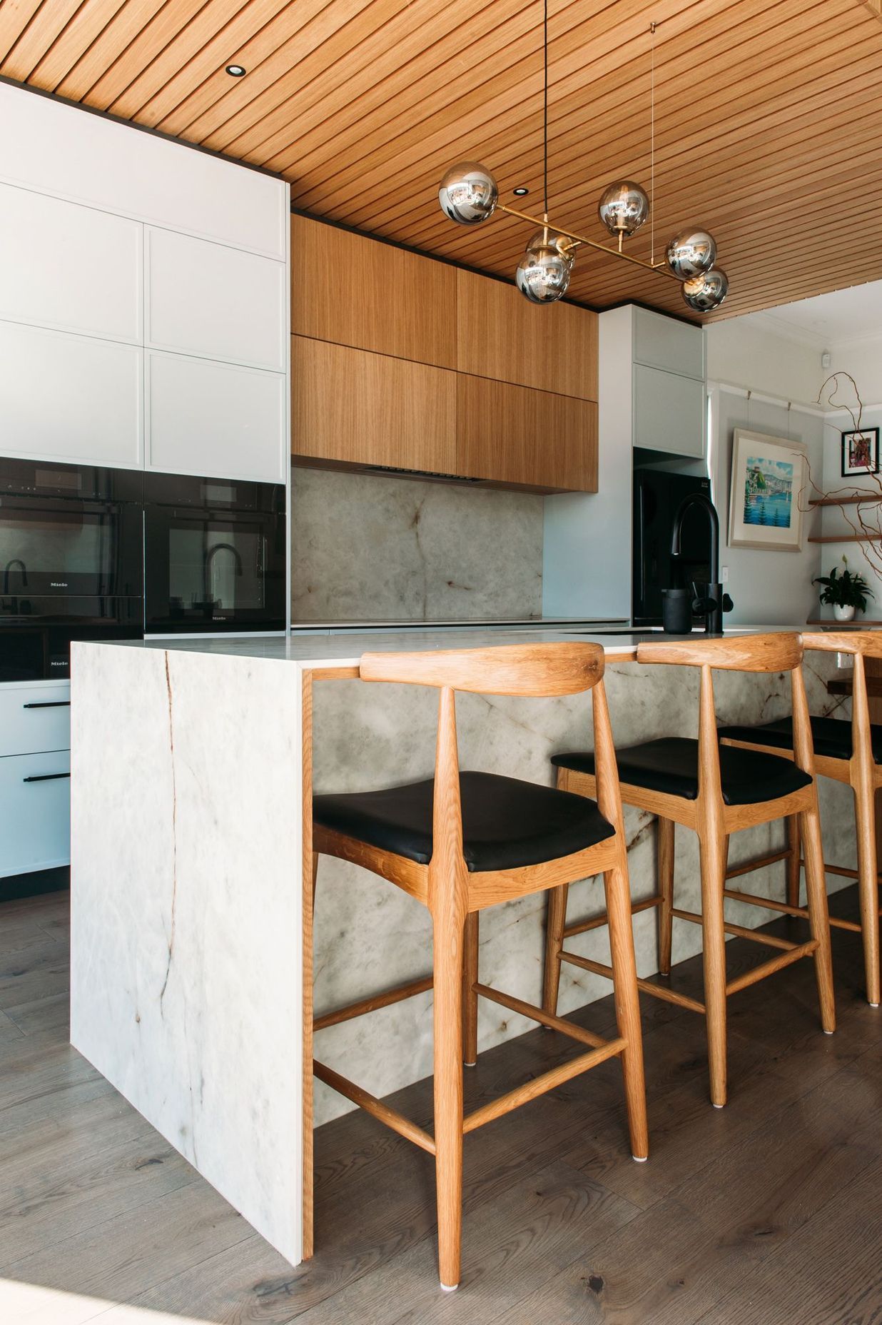 The porcelain benchtop has a waterfall end and ample overhang for the bar stools.