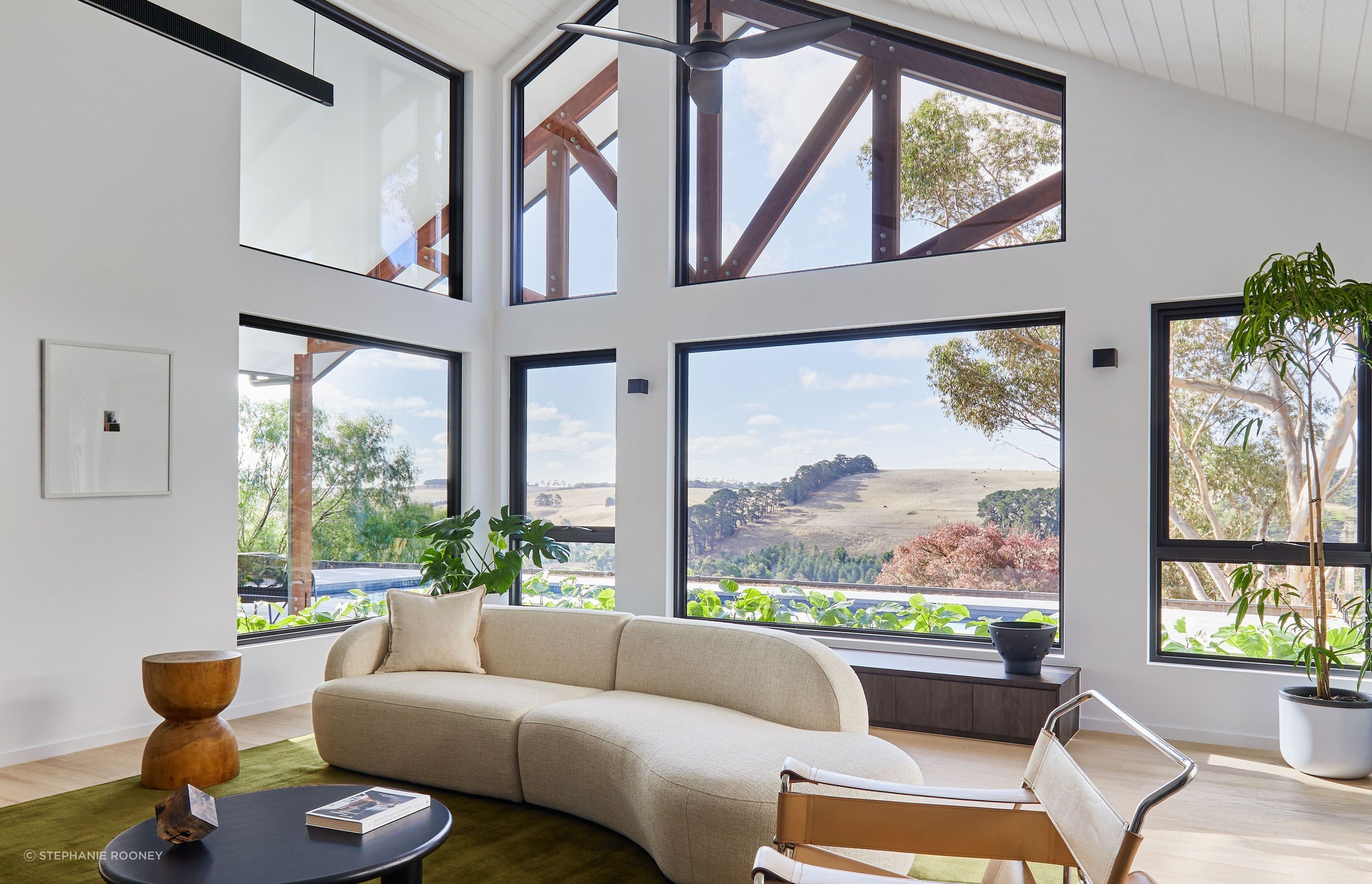 Modern living room interior with large windows overlooking the countryside in Waurn Ponds, VIC. Designed by RUBI Architects, built by Fox Building Group.