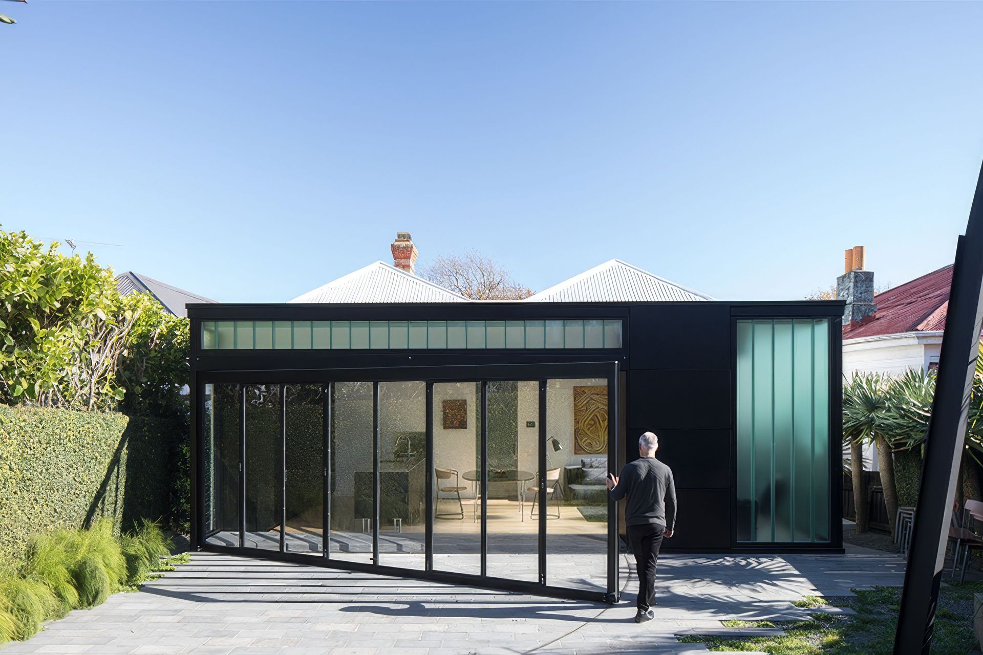 At the rear of the villa is the Lightbox addition, a dramatic contemporary contrast to the detail and filigree of the existing villa. Here, Ken closes the wall tha opens into the backyard.