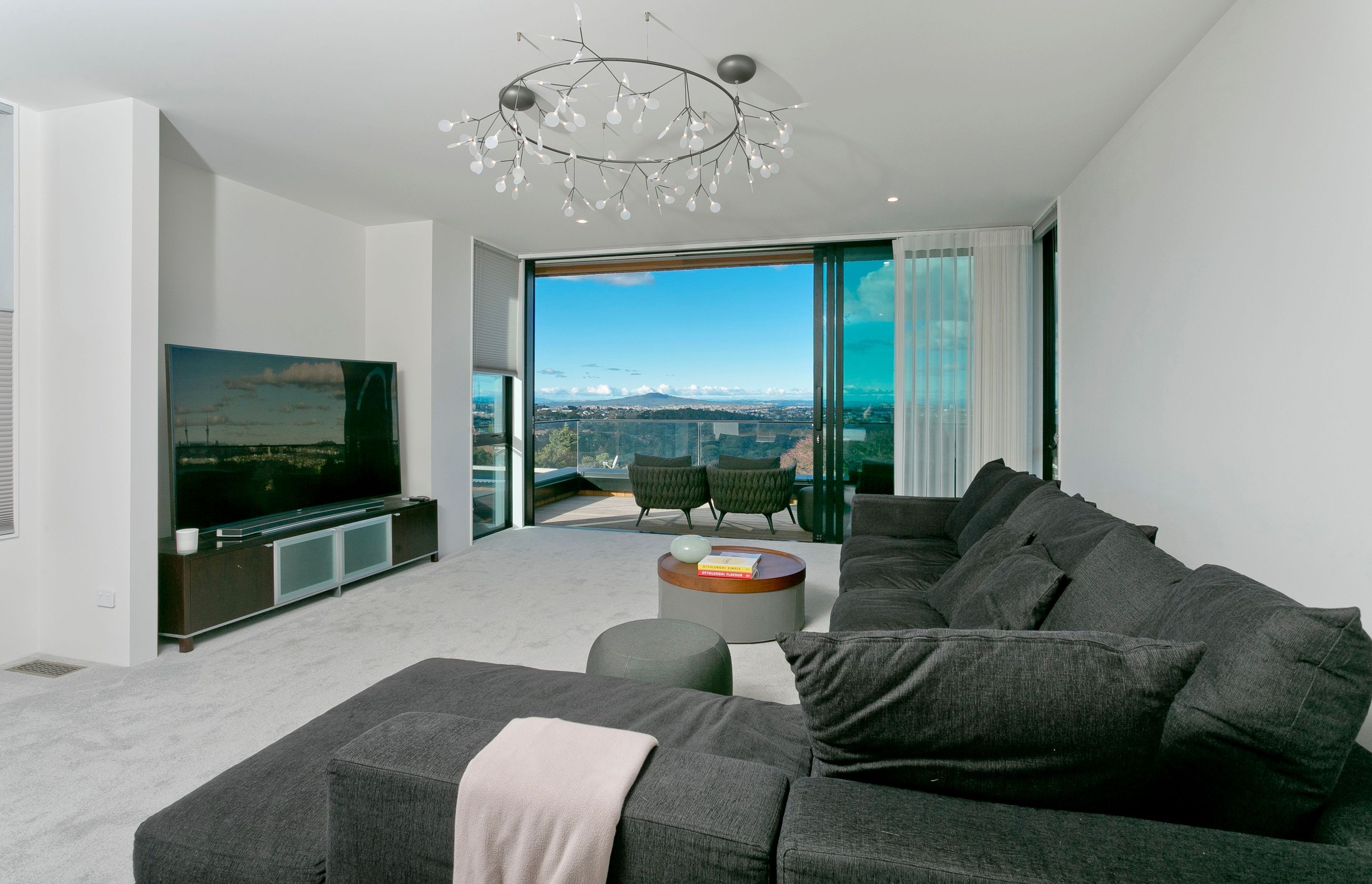 At the rear of the house, a second living area with balcony looking towards Rangitoto in the distance, leads on to the master suite.