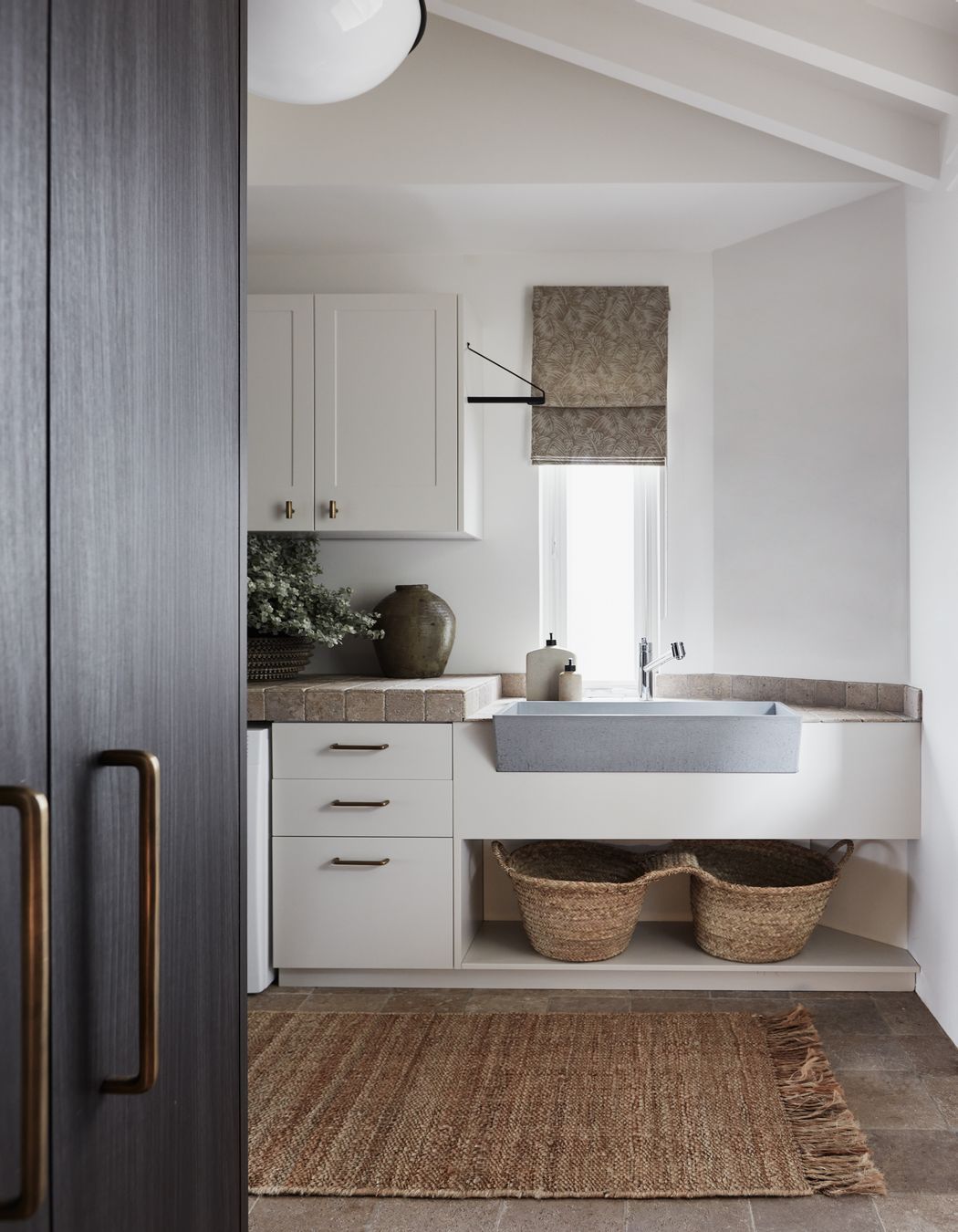 LAUNDRY Walls and benchtop in dark travertine tumbled cobbles, Aeria Country Floors. Joinery in Eveneer Shou Sugi Ban veneer, Elton Group. Argent Esprit kitchen mixer, Arthaus. Henley handles, Hepburn Hardware. Sahara runner, Armadillo.