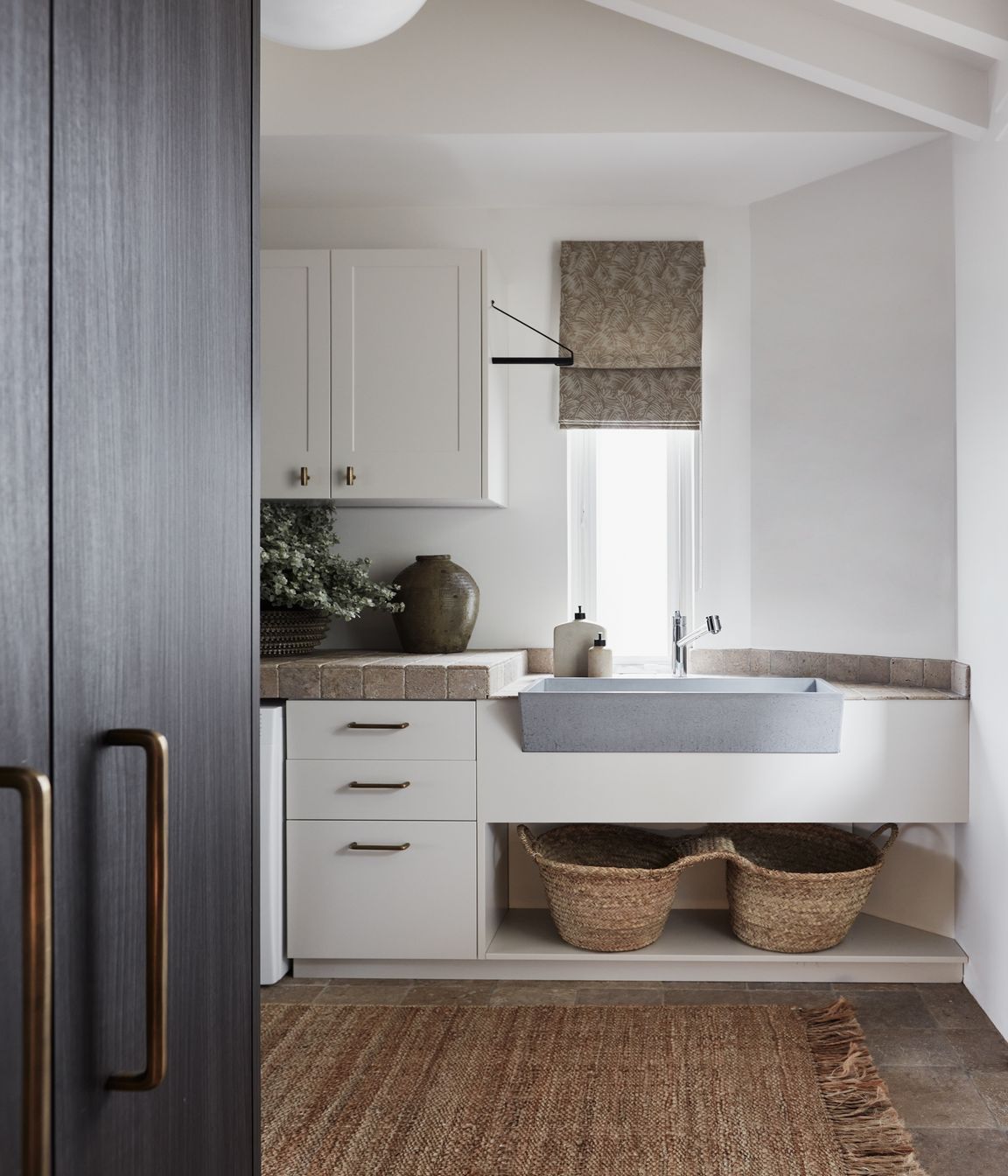 LAUNDRY Walls and benchtop in dark travertine tumbled cobbles, Aeria Country Floors. Joinery in Eveneer Shou Sugi Ban veneer, Elton Group. Argent Esprit kitchen mixer, Arthaus. Henley handles, Hepburn Hardware. Sahara runner, Armadillo.