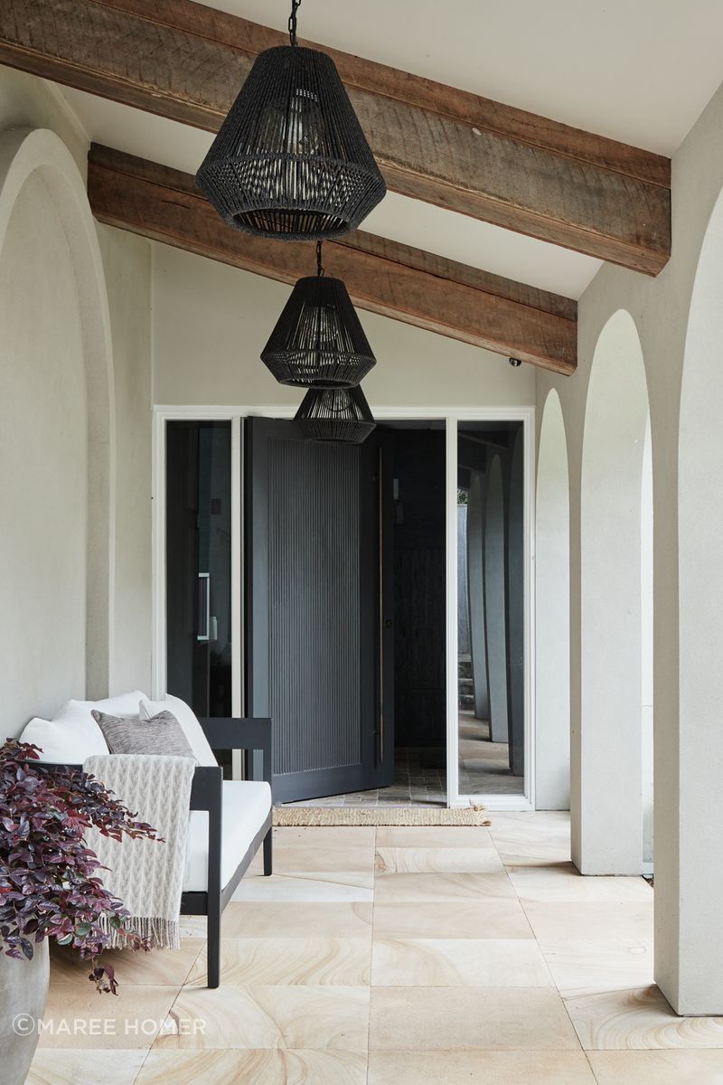 FOYER & ENTRANCE The dark and moody foyer presents a dramatic contrast to the light and breezy covered walkway leading to the front door. Phillip Jeffries ‘Manila Hemp’ wallpaper in Charcoal, The Textile Company. Dark travertine tumbled cobbles, Aeria Country Floors. Arteriors ‘Hogan’ console and Tanner outdoor pendant lights, Boyd Blue. Accessories, Kate Nixon. Avoca outdoor sofa, Horgans. Jilin terracotta pot, Papaya. Sahara entrance mat, Armadillo.