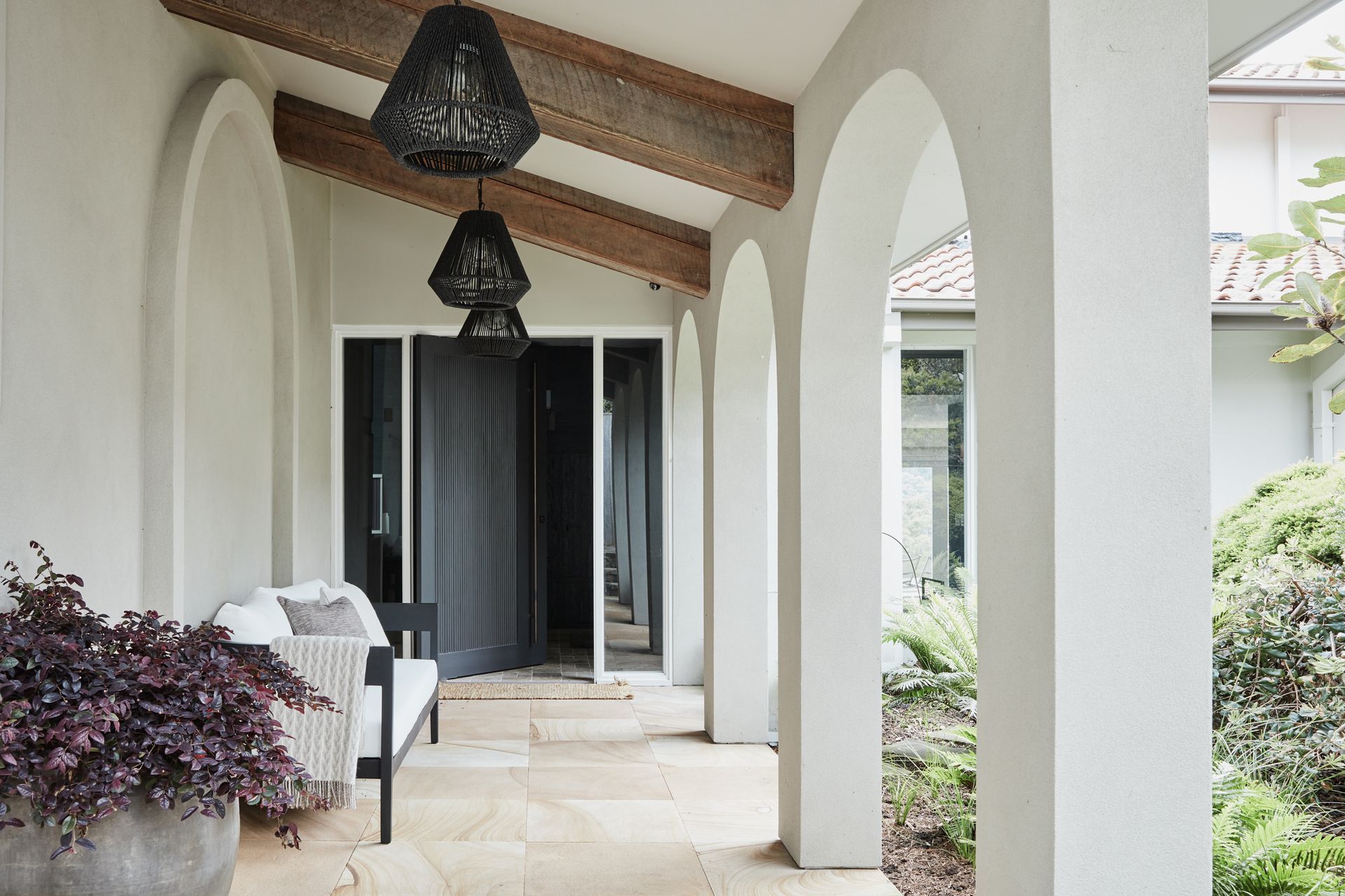 FOYER &amp; ENTRANCE The dark and moody foyer presents a dramatic contrast to the light and breezy covered walkway leading to the front door. Phillip Jeffries ‘Manila Hemp’ wallpaper in Charcoal, The Textile Company. Dark travertine tumbled cobbles, Aeria Country Floors. Arteriors ‘Hogan’ console and Tanner outdoor pendant lights, Boyd Blue. Accessories, Kate Nixon. Avoca outdoor sofa, Horgans. Jilin terracotta pot, Papaya. Sahara entrance mat, Armadillo.
