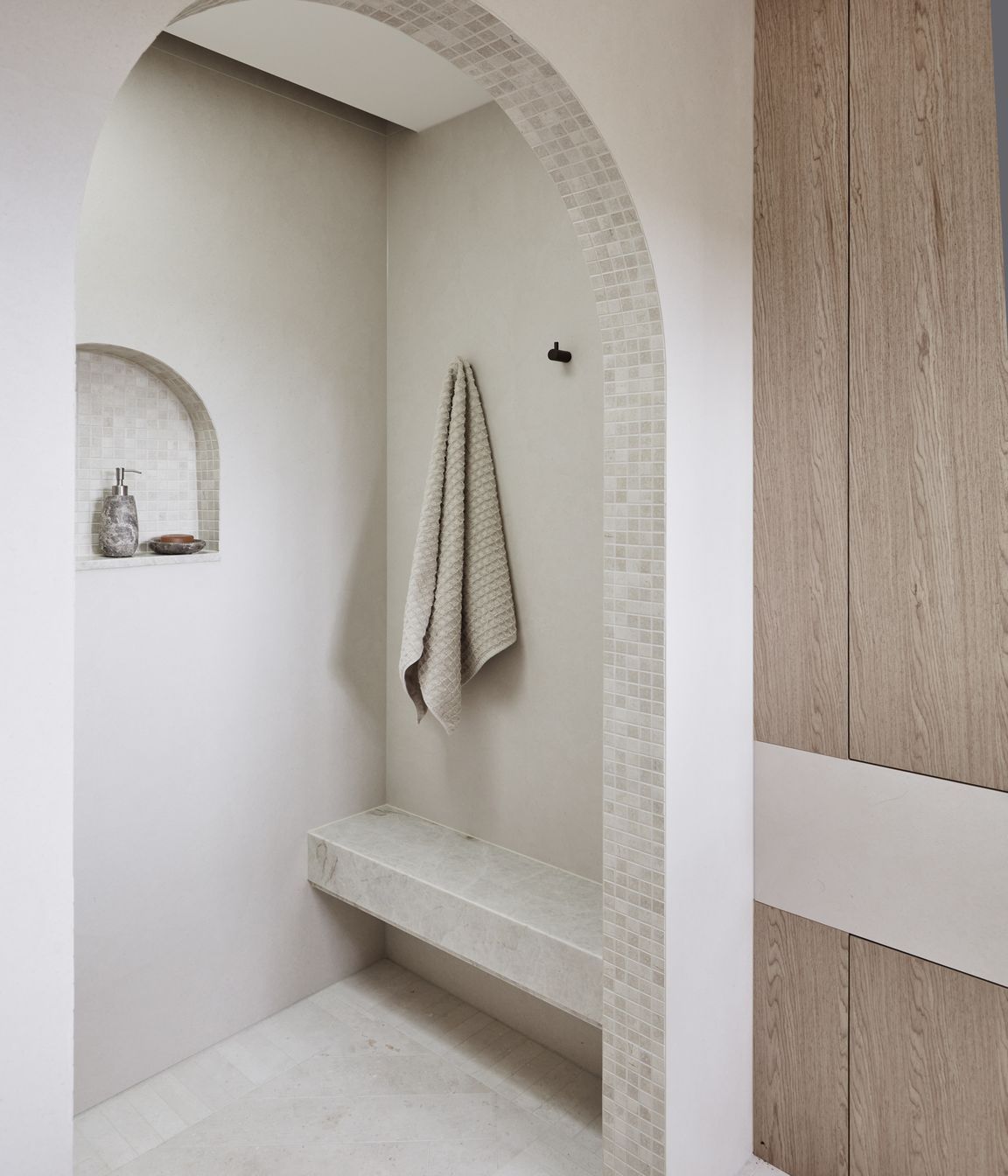 MAIN ENSUITE Kone White matt wall tiles and benchtop, Rocks On. Raw-sawn limestone floor tiles and porcelain matt arch mosaics, all Onsite Supply+Design. Bouchon veneer, Briggs Veneers.