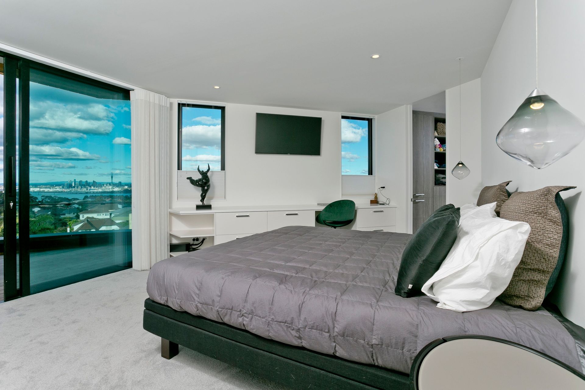 The master bedroom enjoys a balcony of its own and similar panoramic views of Auckland city.