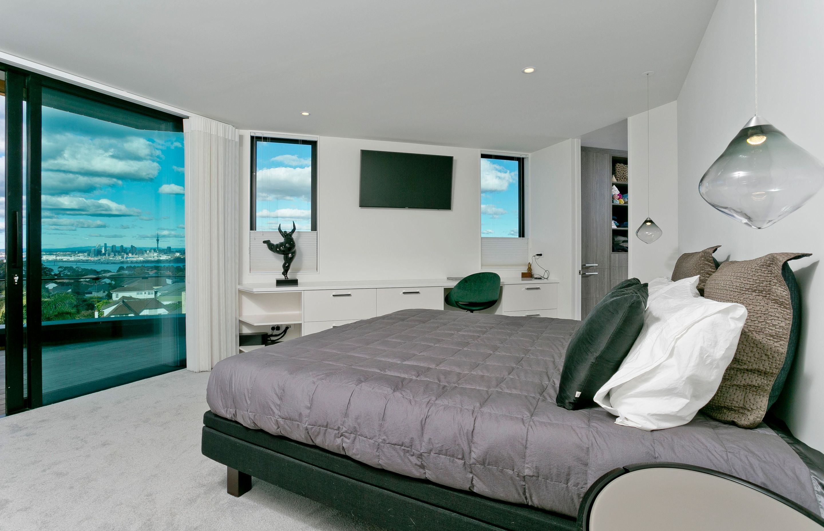 The master bedroom enjoys a balcony of its own and similar panoramic views of Auckland city.