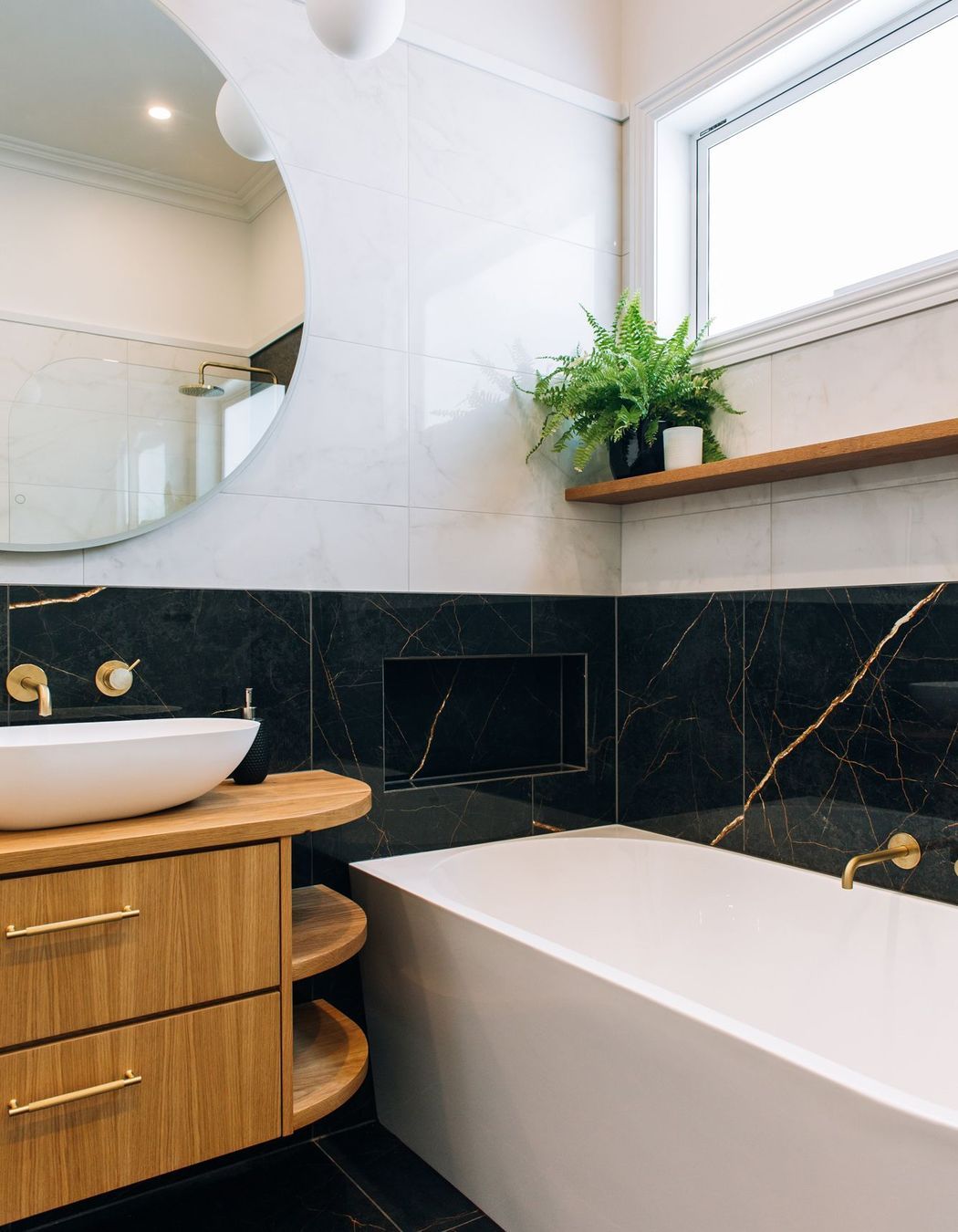A generous bath with tiled shelf and accessories nook.