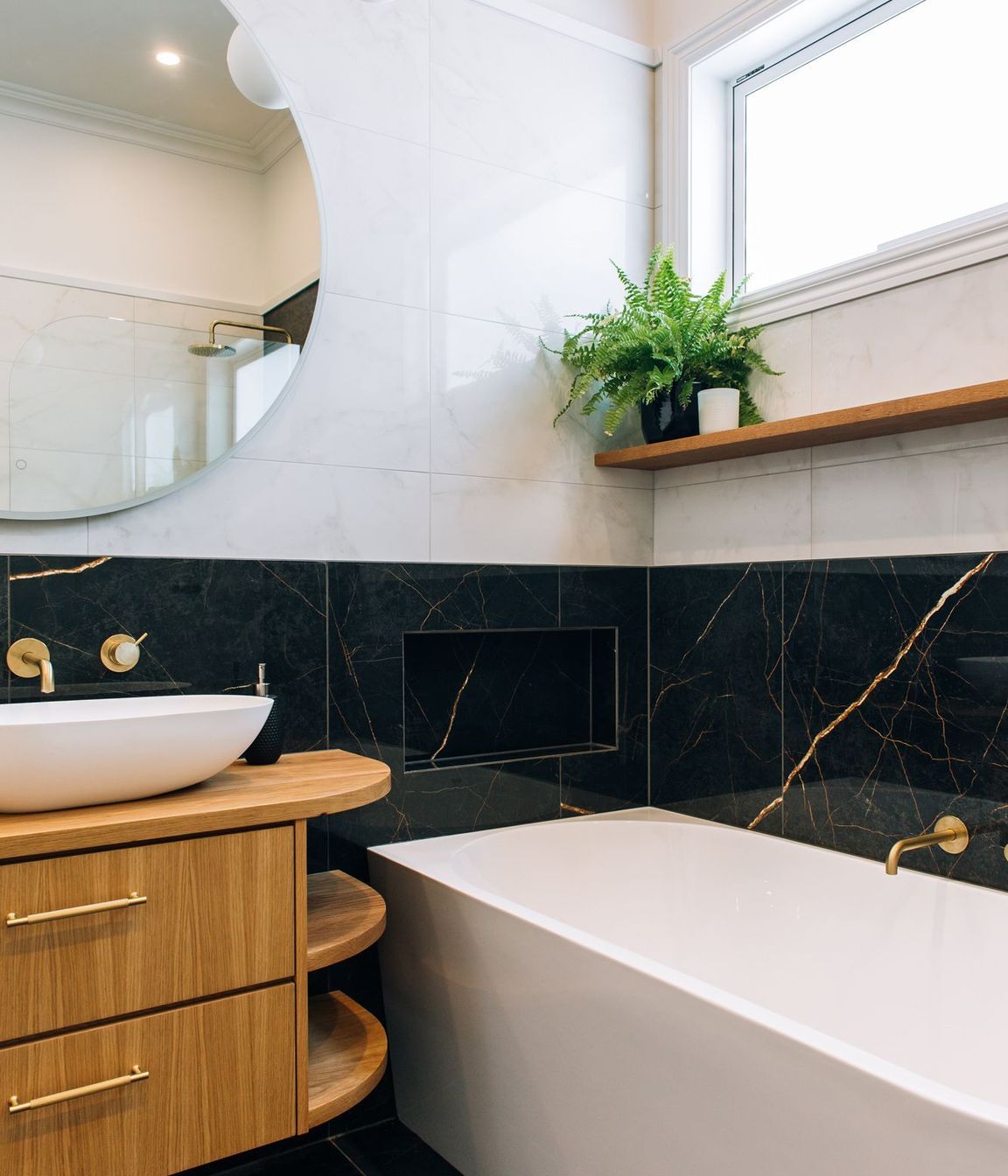 A generous bath with tiled shelf and accessories nook.