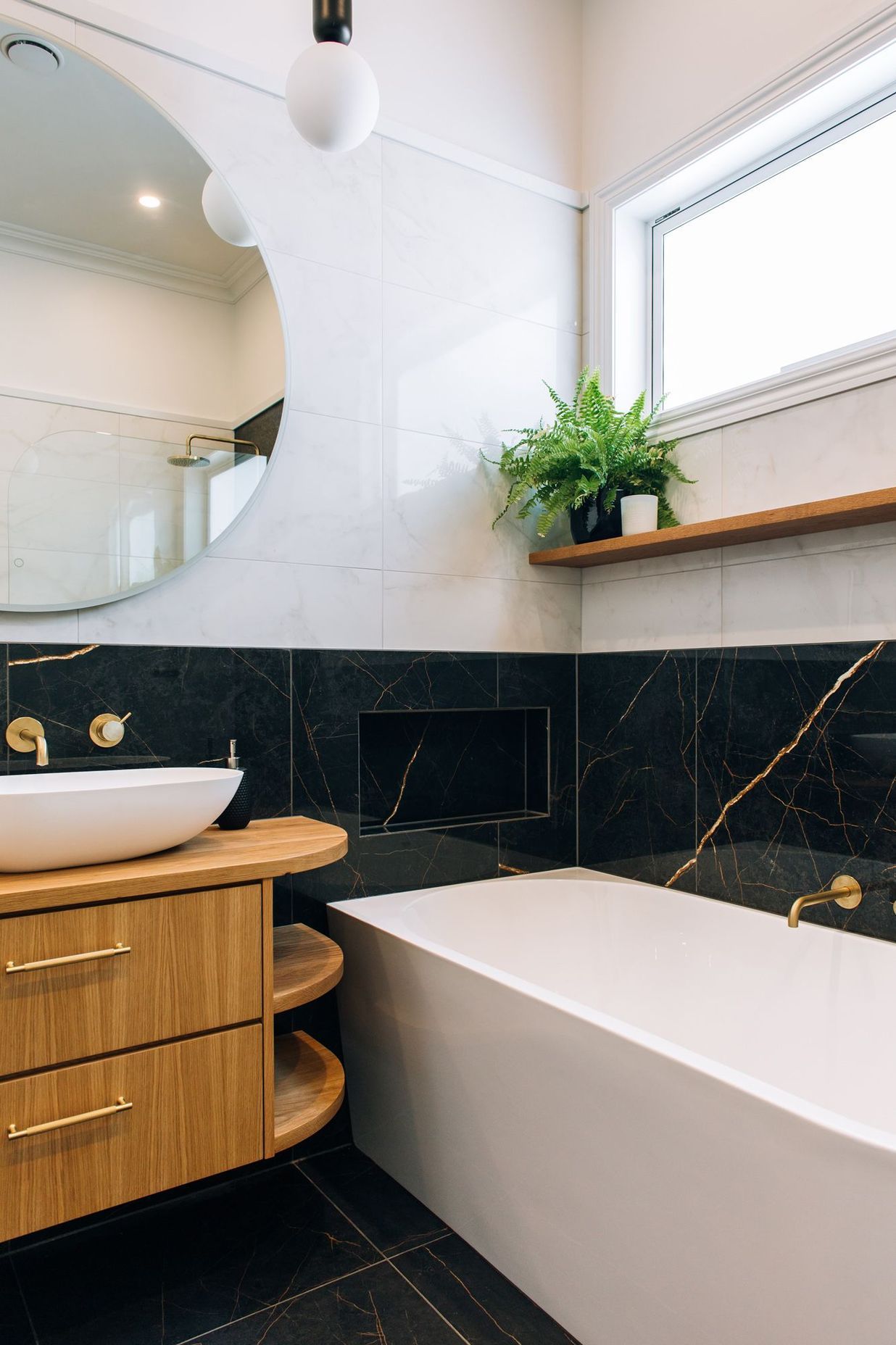 A generous bath with tiled shelf and accessories nook.