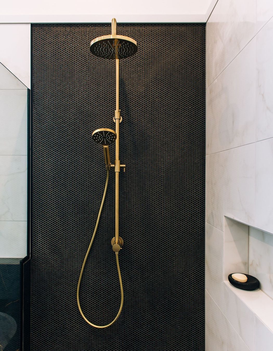 Dual shower heads on the mosaic tiled wall.