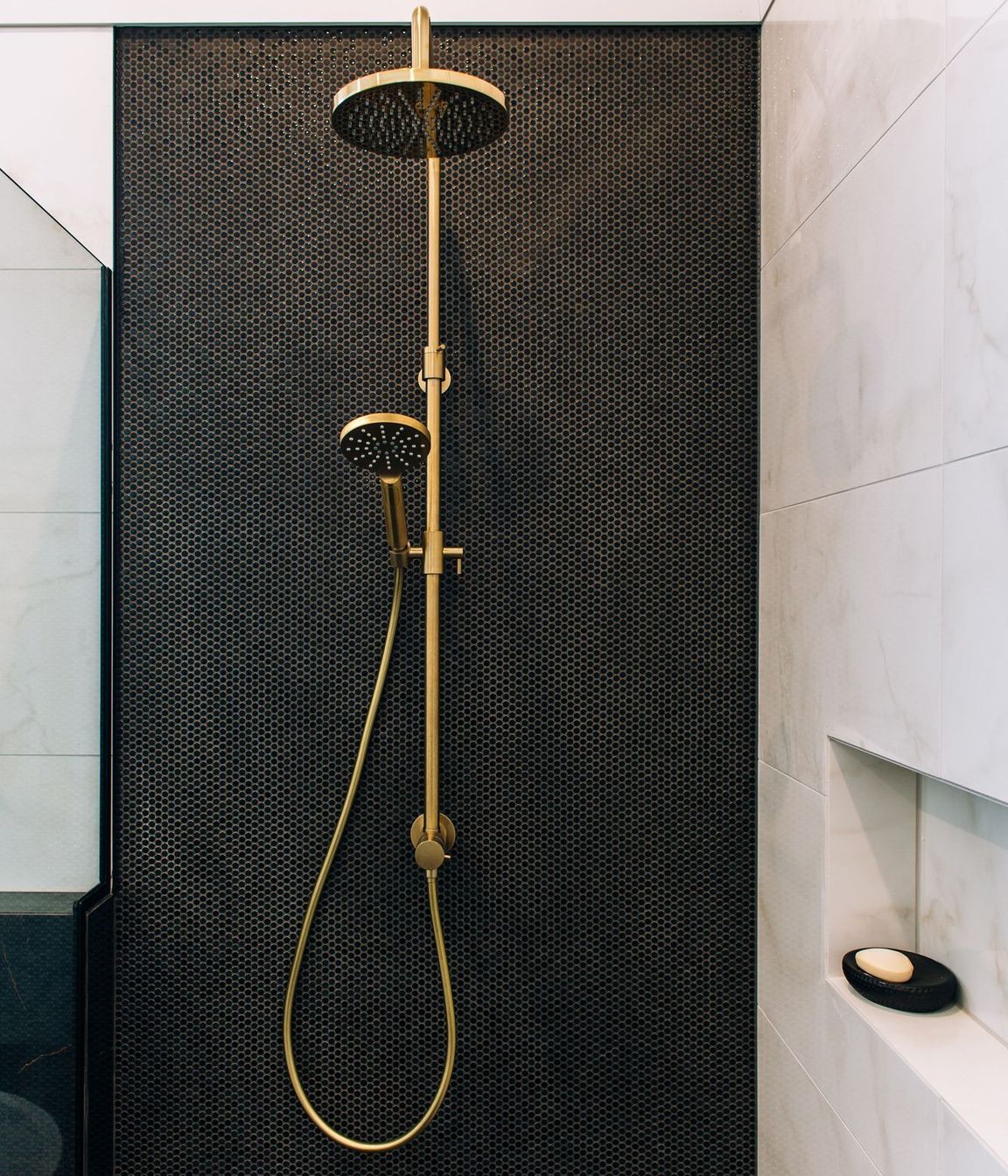 Dual shower heads on the mosaic tiled wall.