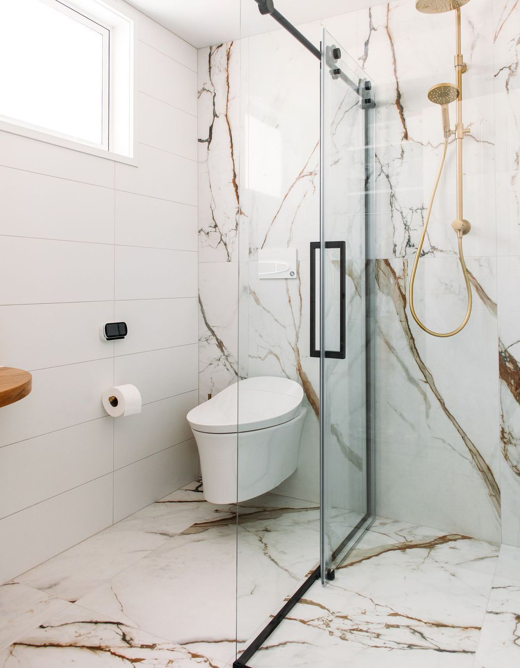 A wall hung smart toilet fit the brief in this tiled bathroom.