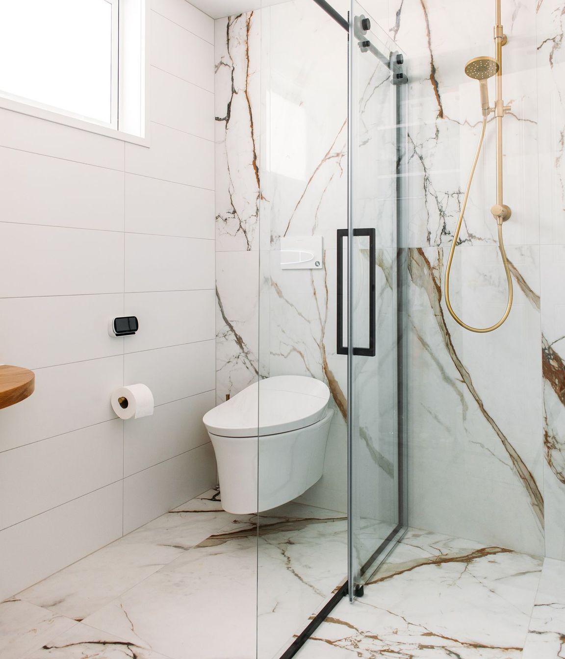 A wall hung smart toilet fit the brief in this tiled bathroom.