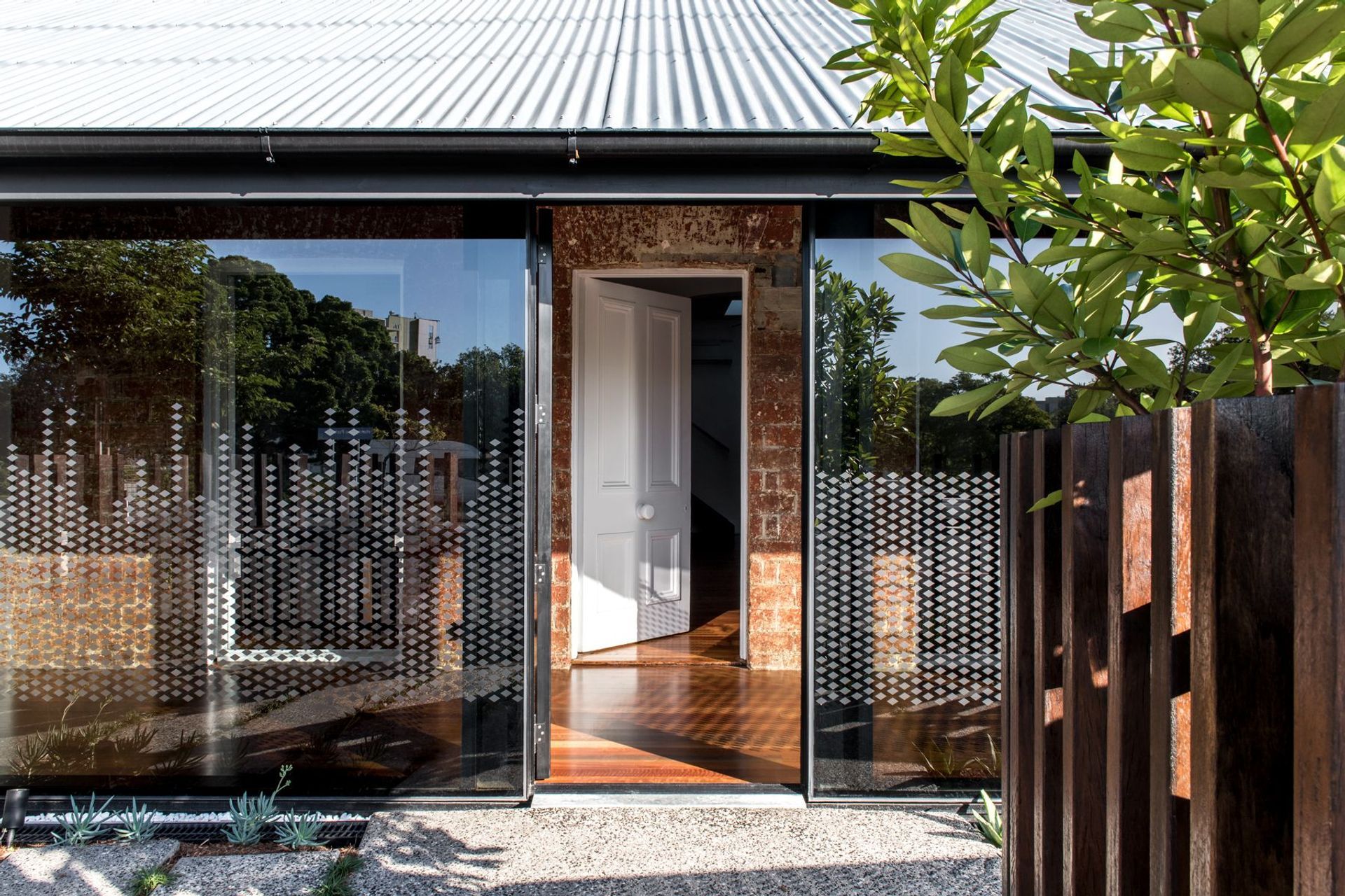Photography: Cathy Schusler | The tinted glass facade along the front verandahs creates a strong contrast to the heritage brick facade behind.