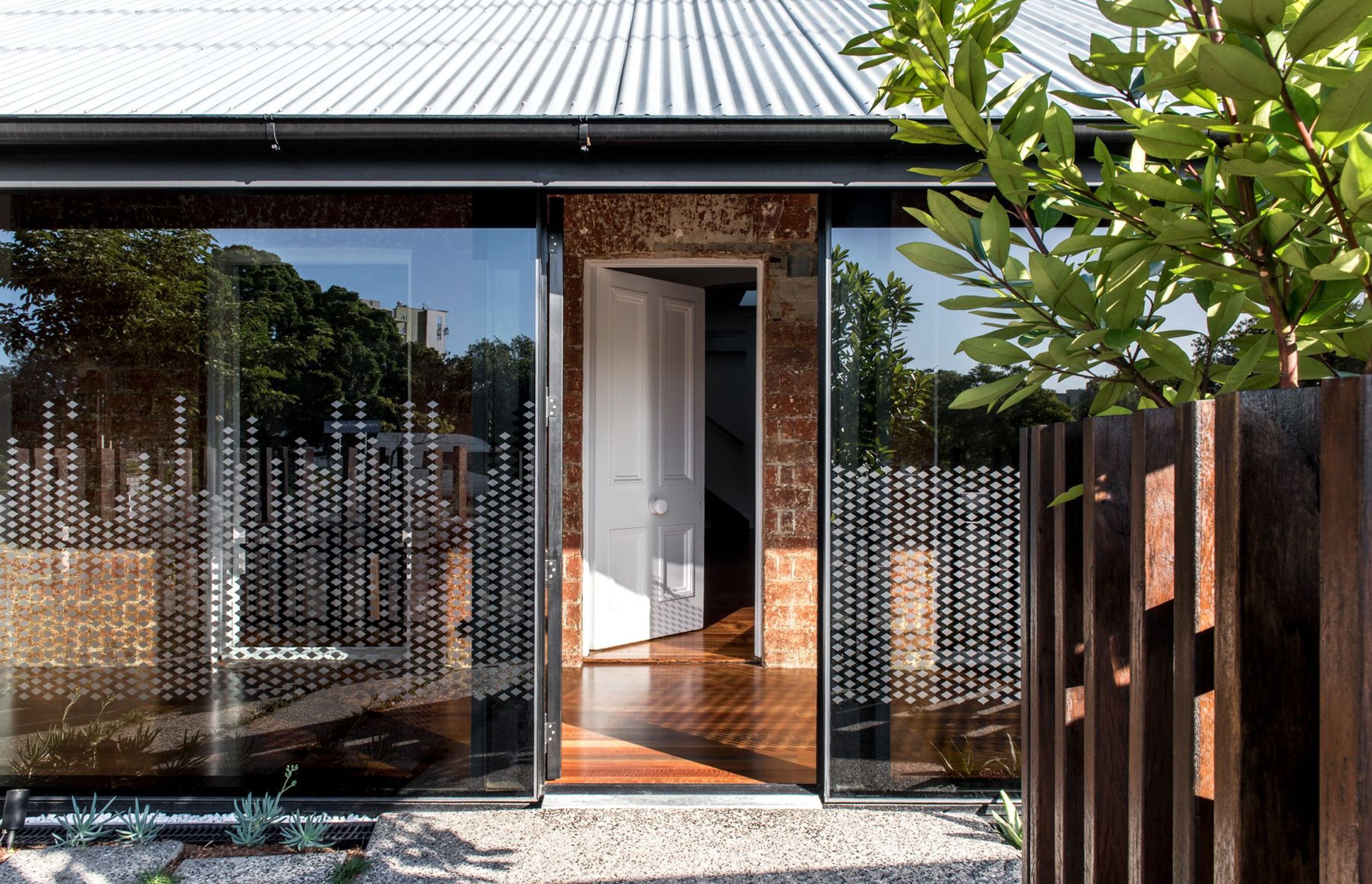 Photography: Cathy Schusler | The tinted glass facade along the front verandahs creates a strong contrast to the heritage brick facade behind.