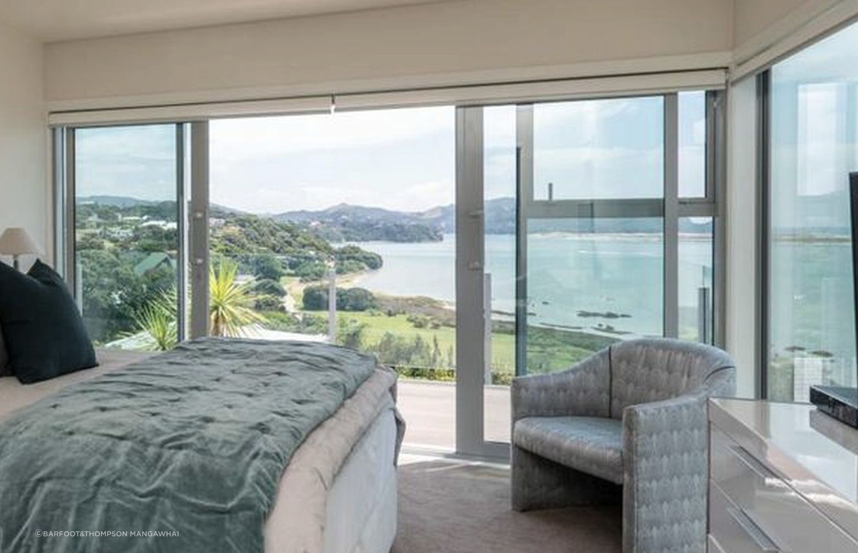 Bi-parting sliding doors lead from master bedroom to East facing deck