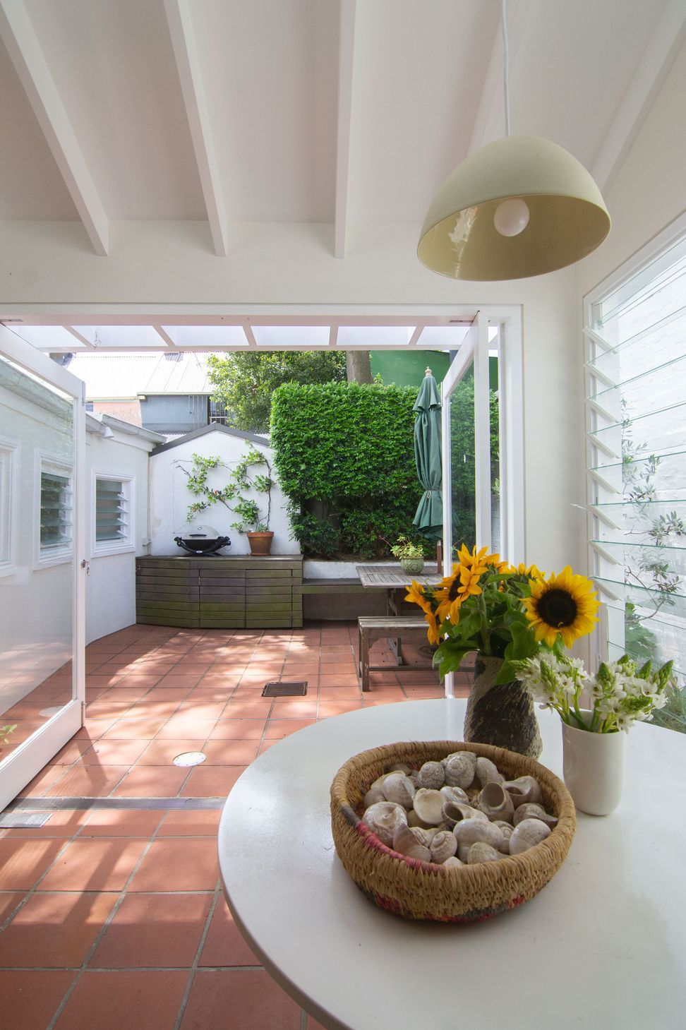 Seamless terracotta tiles flow from the interior space to the rear outdoor garden space