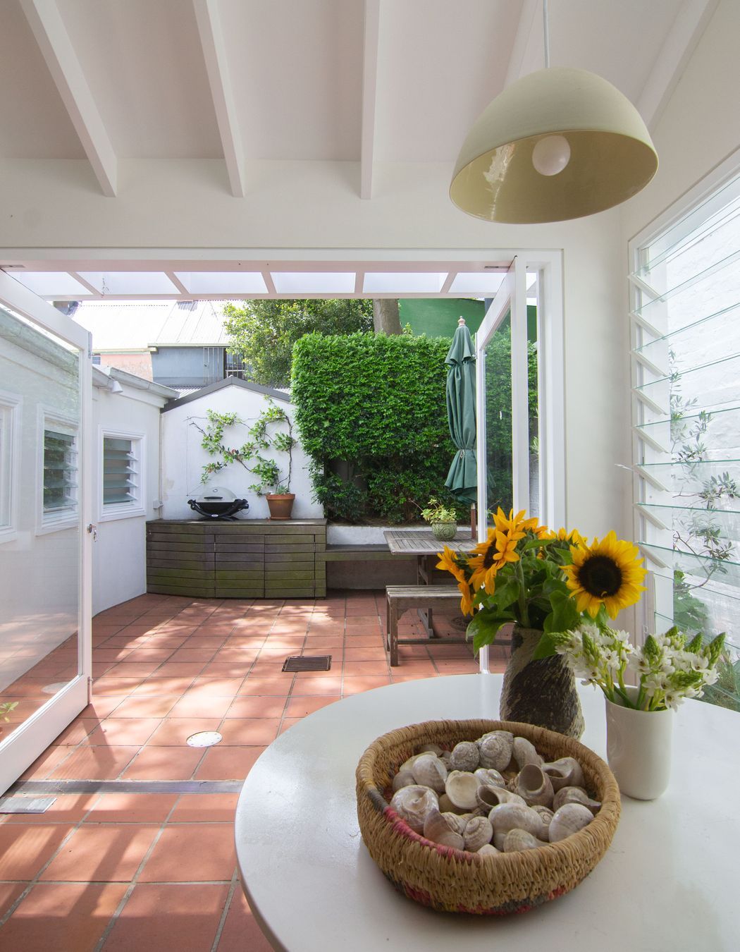 Seamless terracotta tiles flow from the interior space to the rear outdoor garden space