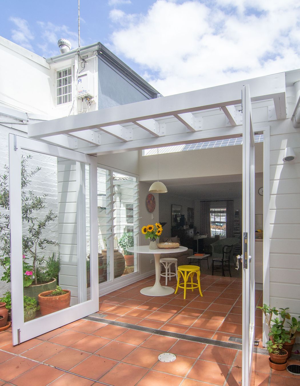 Cottage expression expanded from the interior of the home to the new addition with a timber pergola