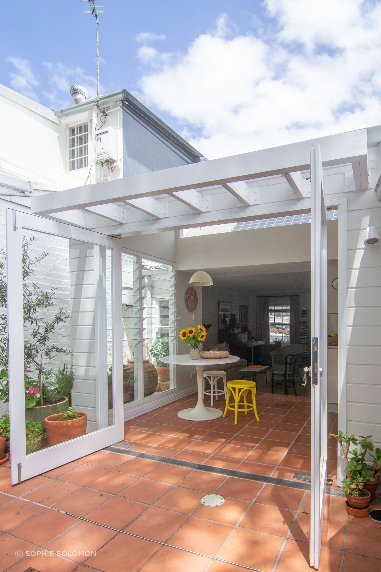 Cottage expression expanded from the interior of the home to the new addition with a timber pergola