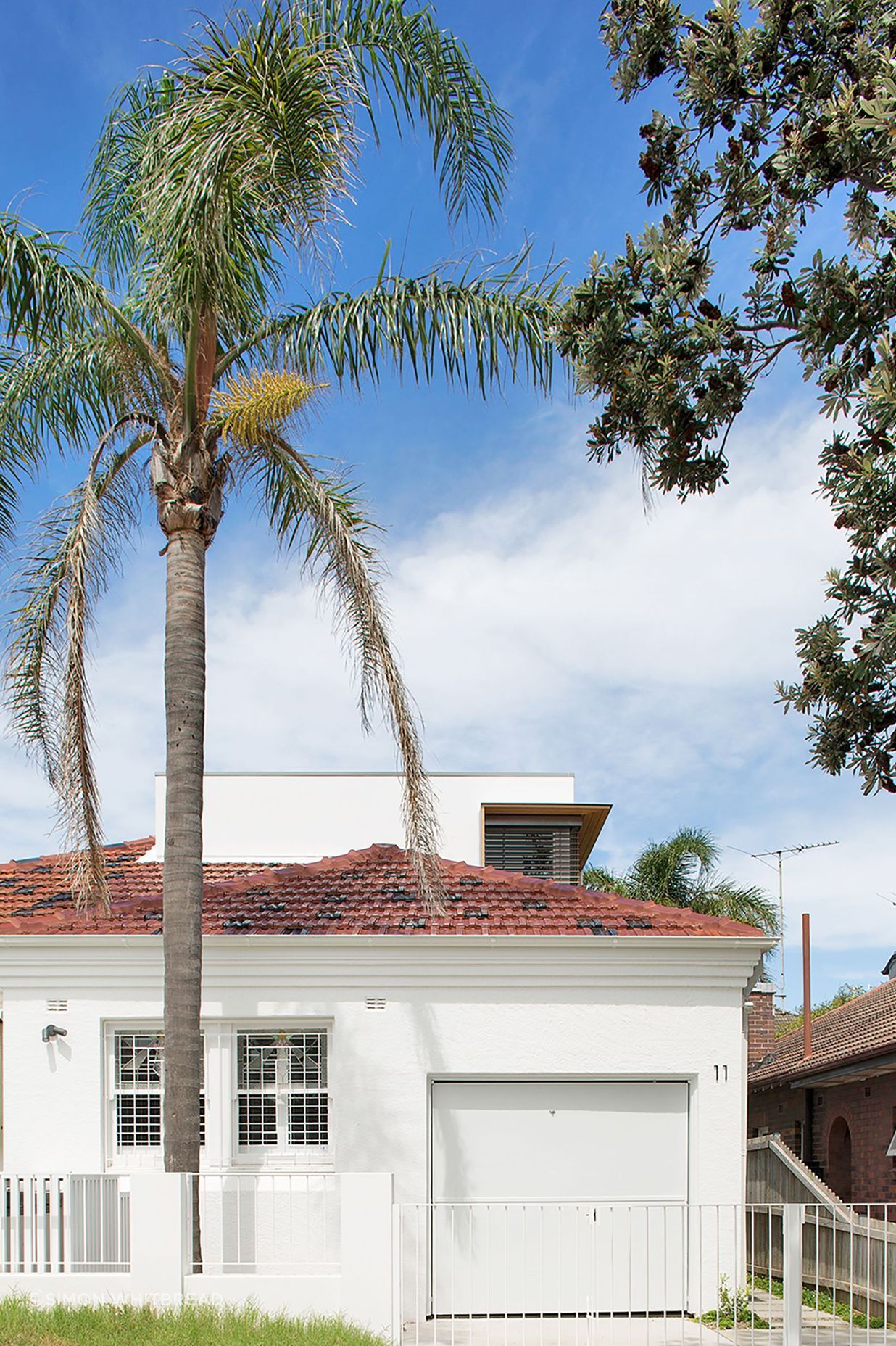 Street view with the second storey addition sitting discreetly behind the existing roof line.