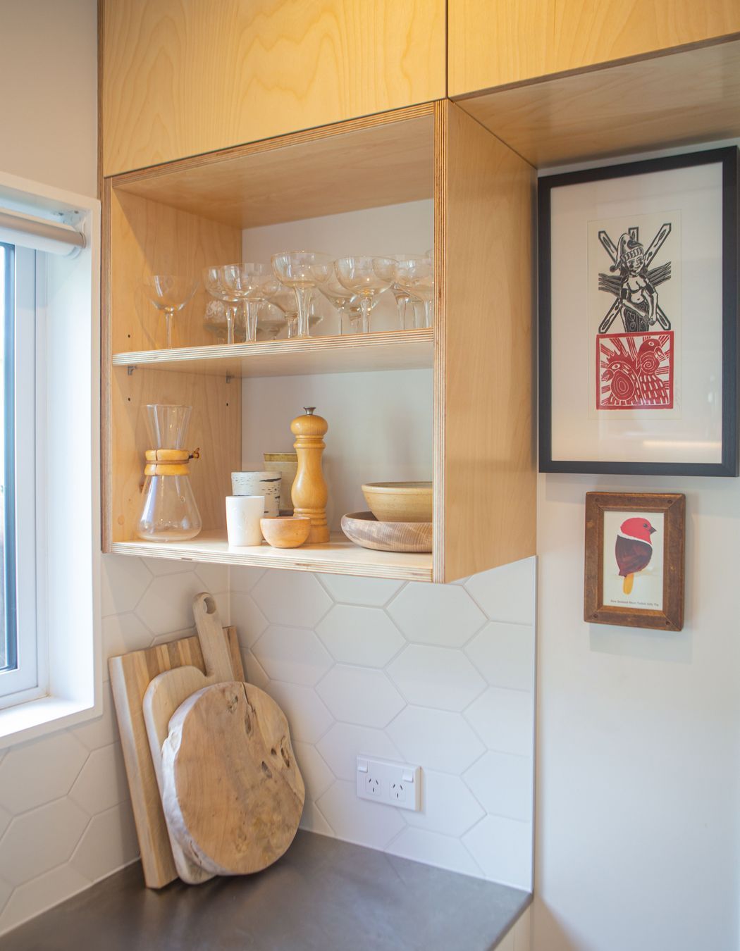 Open birch plywood shelving made use of the spaces around the window frame.
