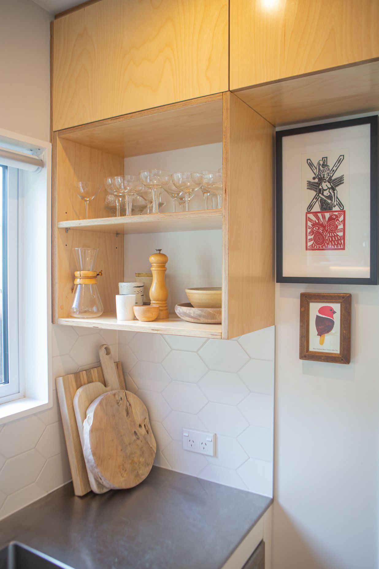 Open birch plywood shelving made use of the spaces around the window frame.