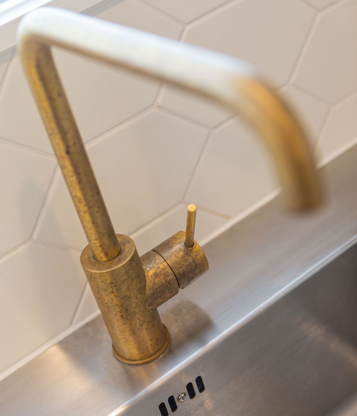 Brushed brass gooseneck tapware, has worn a beautiful patina with age.