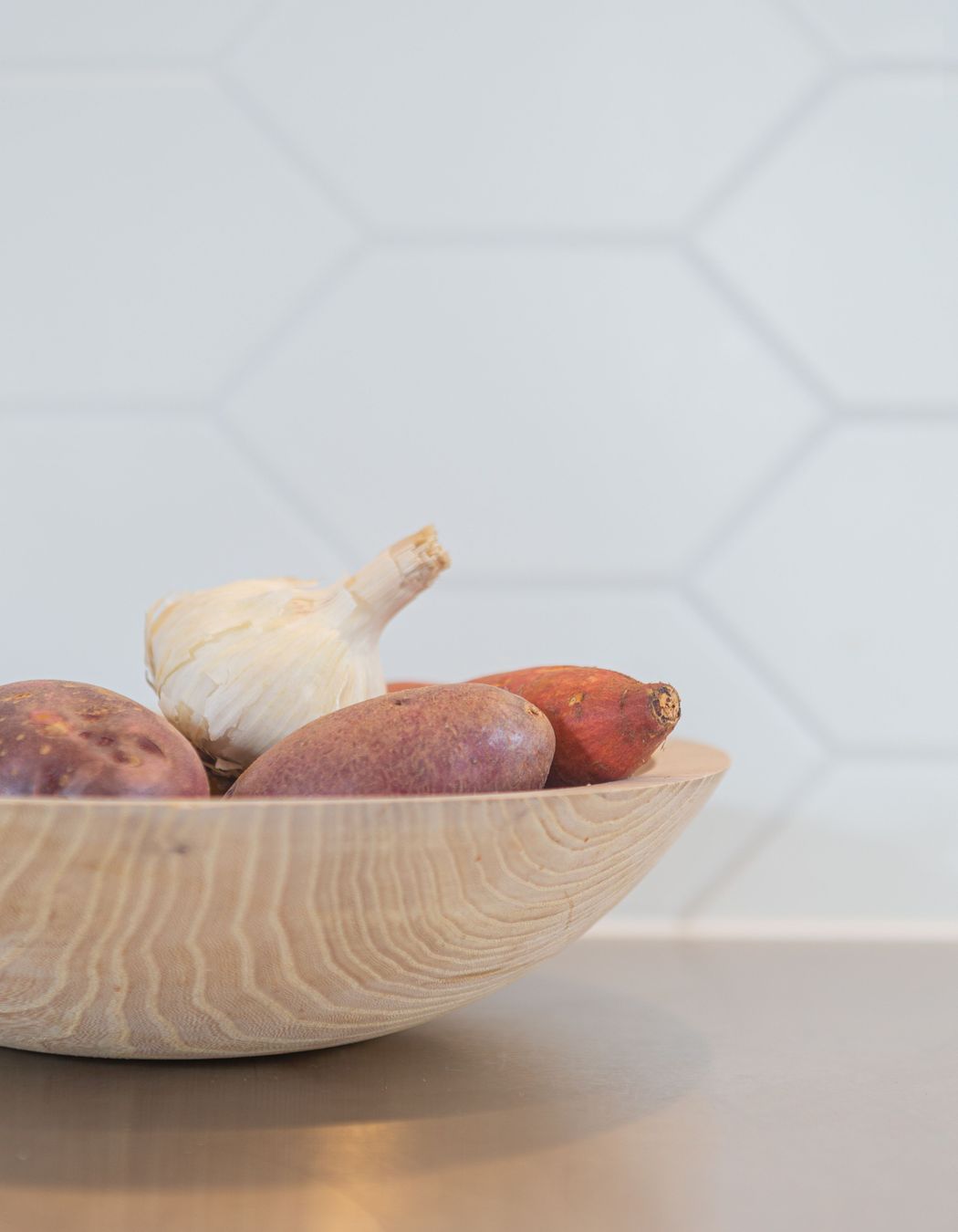 Elongated hexagonal tiles and a stainless steel benchtop add to the textures and practicality of this kitchen.