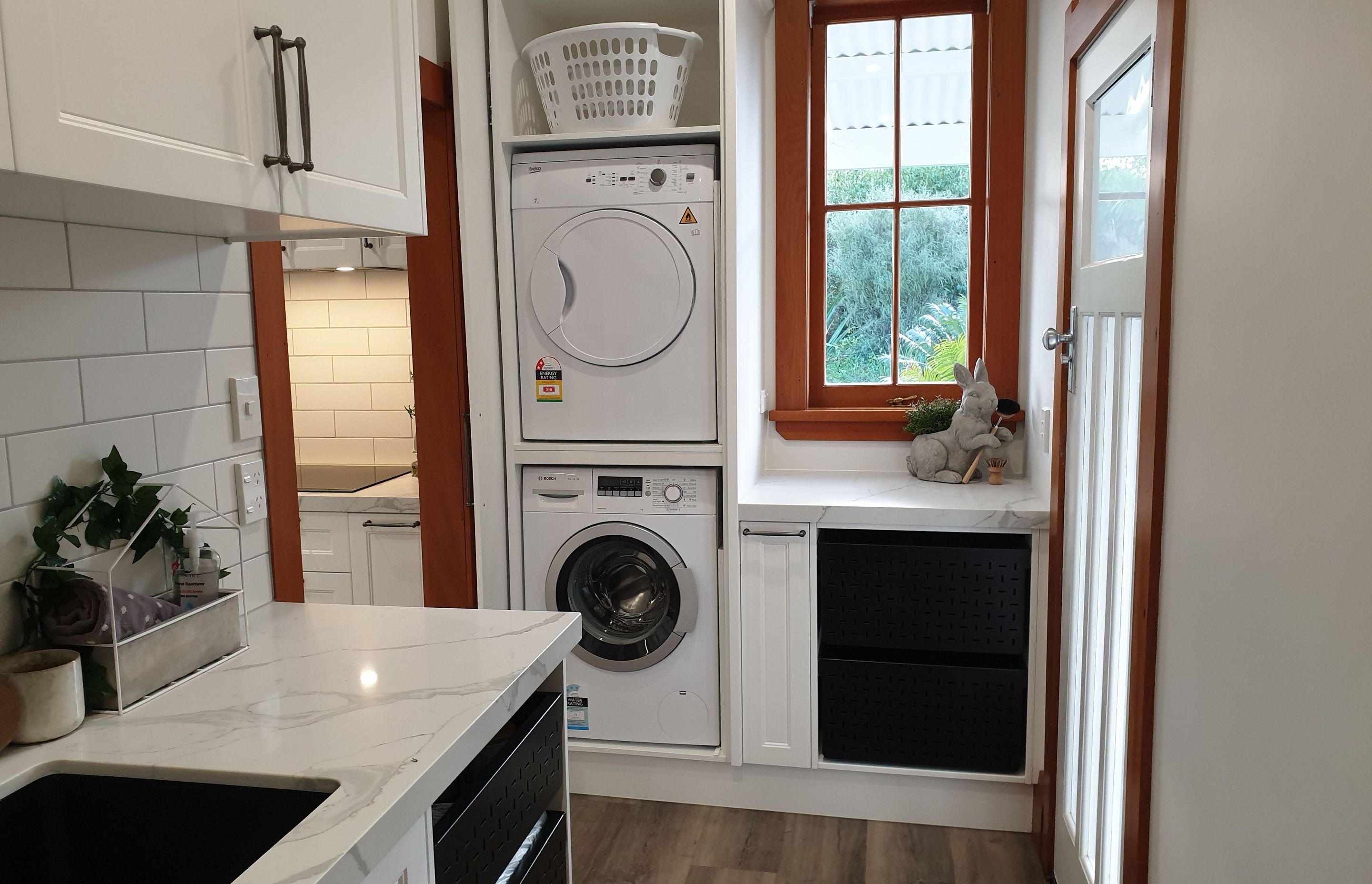 Salice Pocket Door Used to Create an Efficient Laundry Appliance Cupboard - Seen Here with Door Open