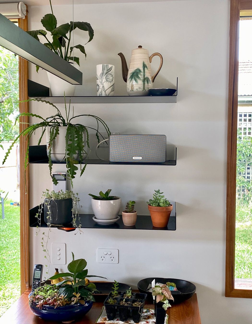 Custom designed display shelves in the kitchen feature favorite ceramics and plants