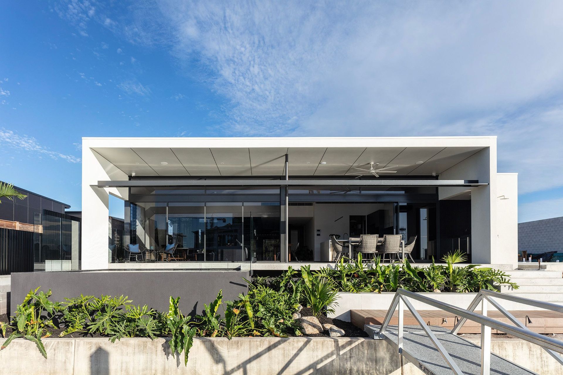 Bells Esplanade - Exterior. Street elevation with a floating white upper level and landscaped frontage.