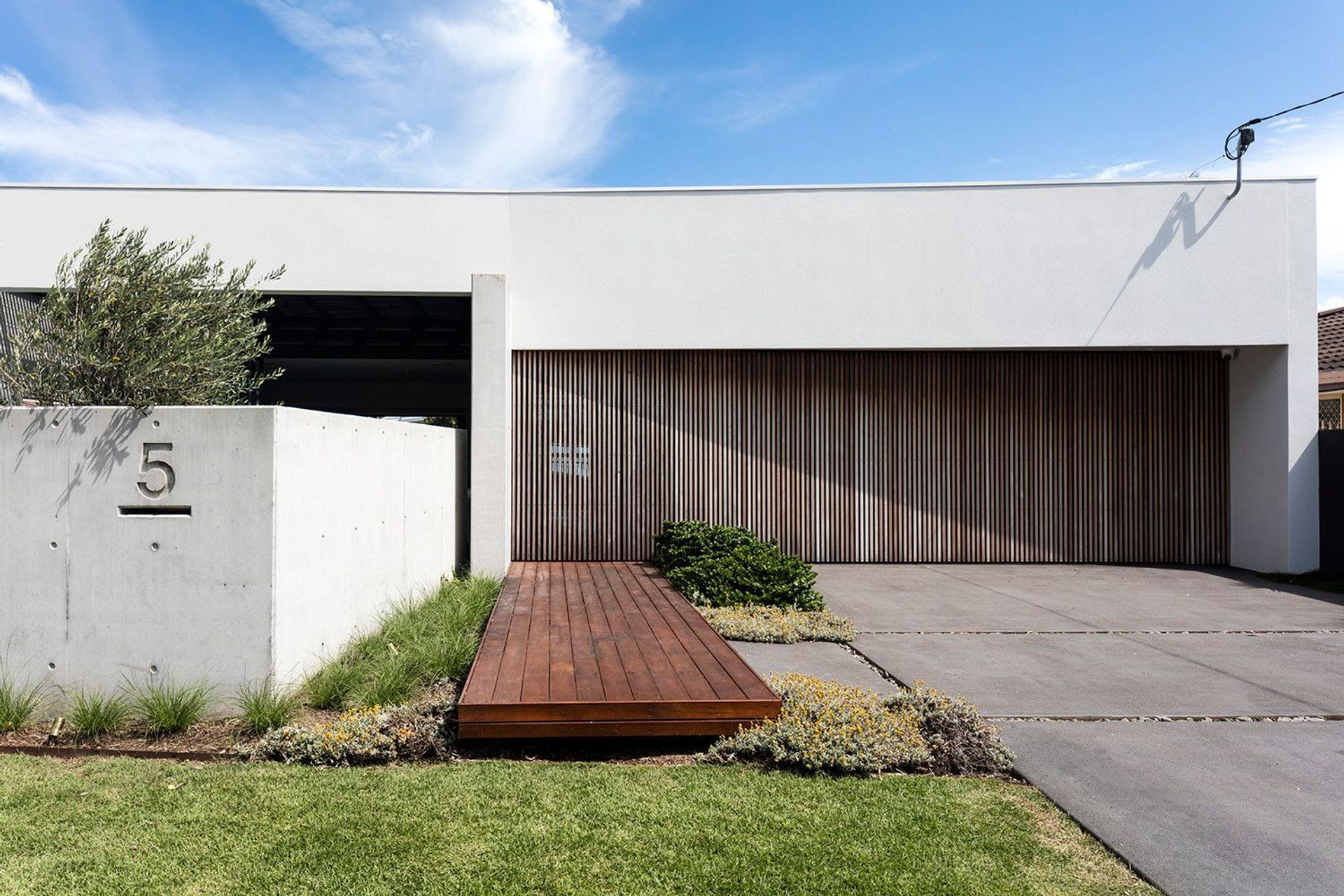 Morrison Residence - Exterior. Timber clad garage and house number wall.