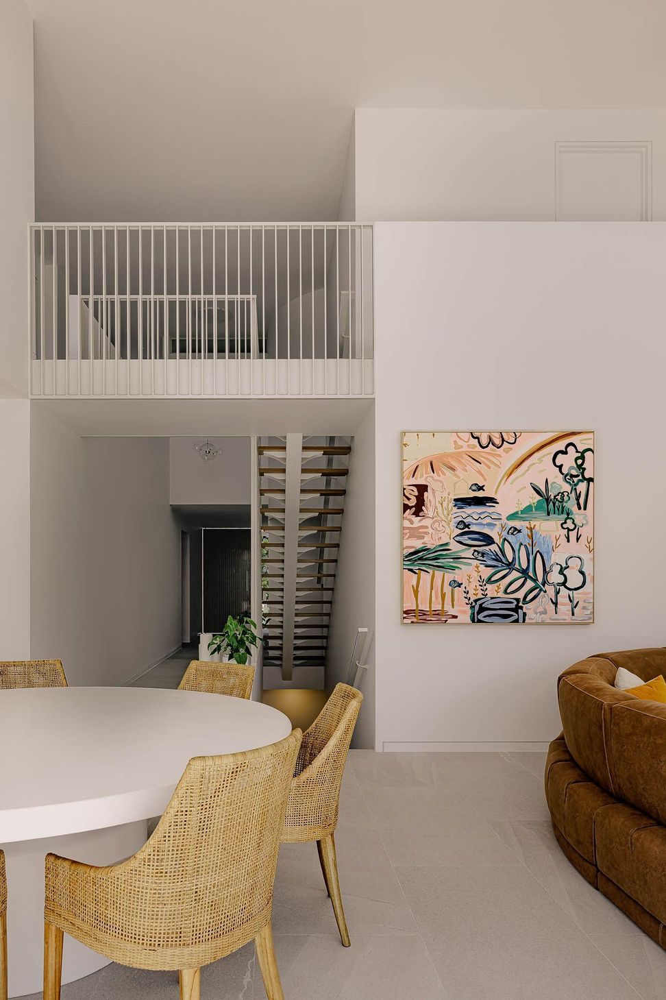 Zaremba Residence - Dining Room. Dining area beneath a bridge with bold artwork.