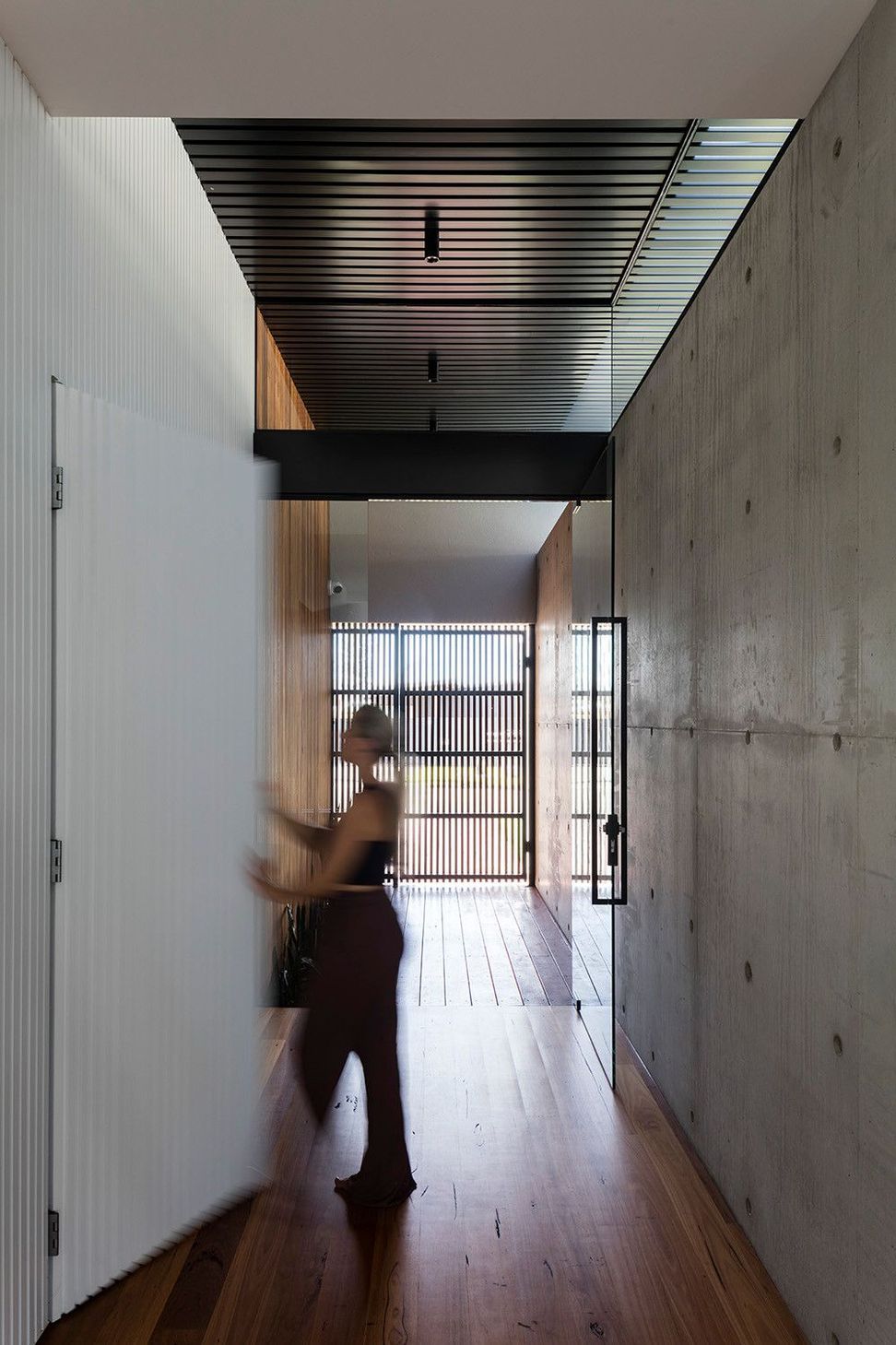 Morrison Residence - Entry. Concrete entry with a timber battened door.