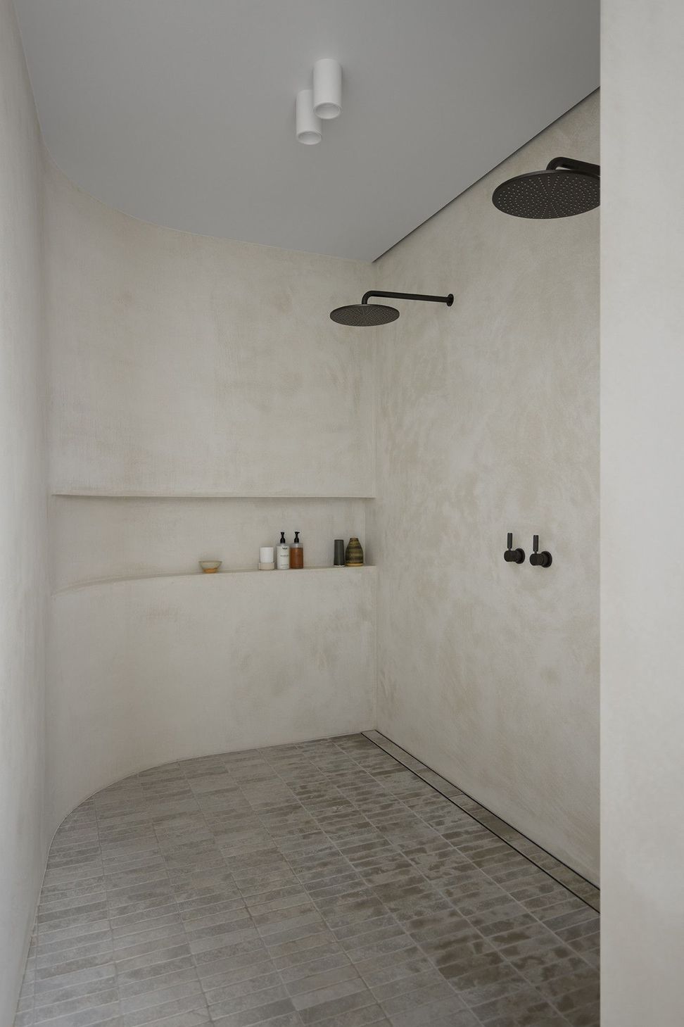 Villa Solare - Bathroom. Open shower with a concrete bench and stone floor.