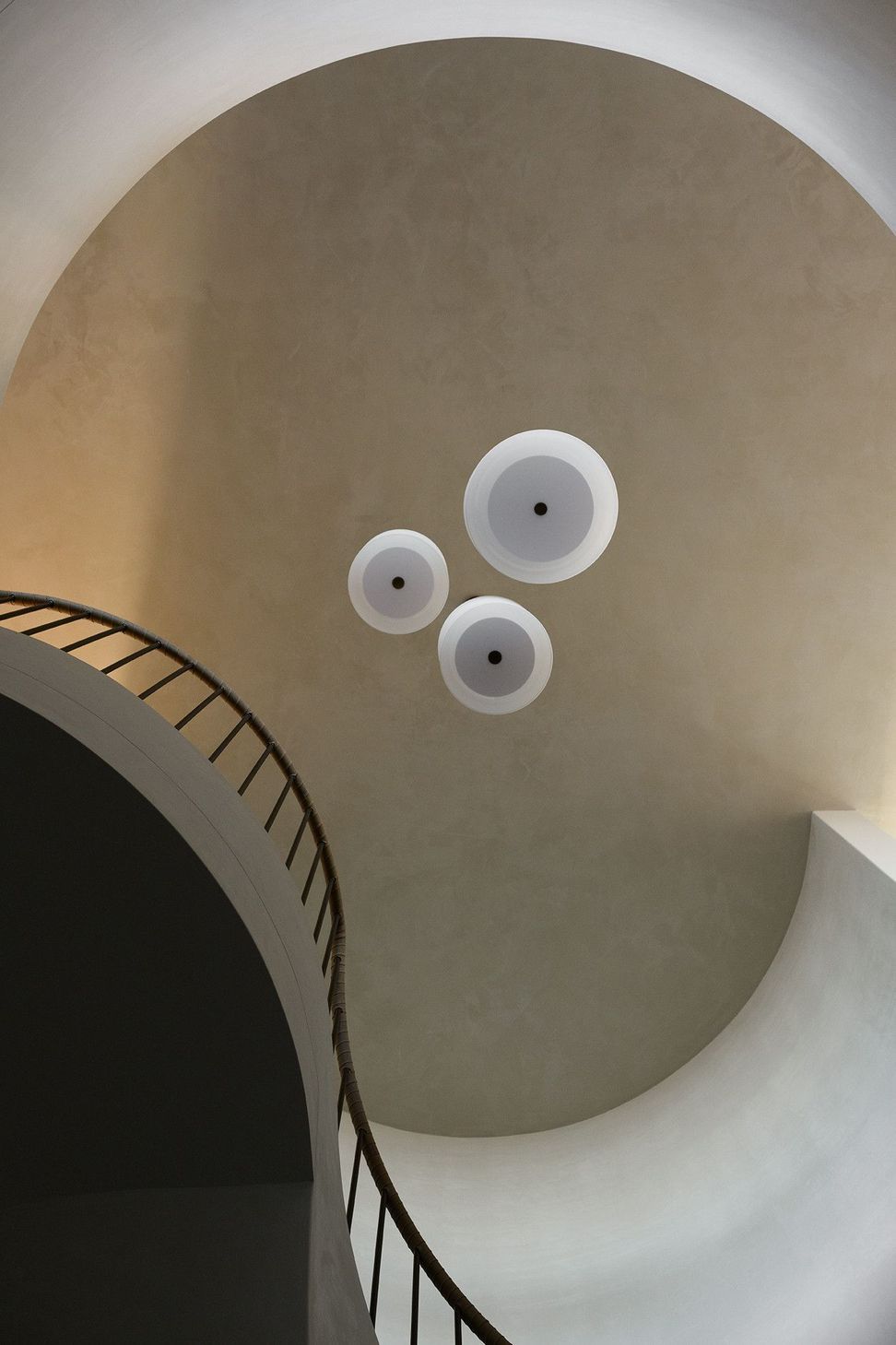 Villa Solare - Staircase. Looking up the curved stair to cluster pendant lights.