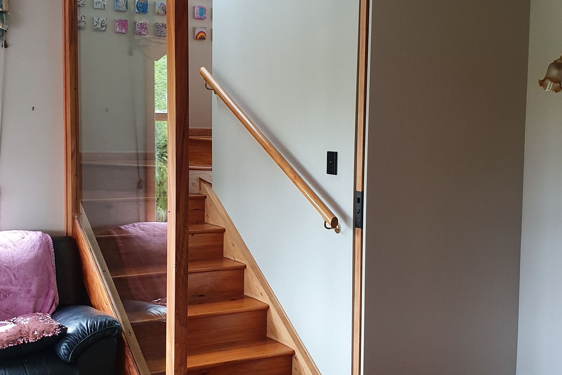 Recycled timber (inset) sliding door and glass panel installed to separate lower section of house from the main part of the house. Glass panel ensures light can circulate and keeps the area looking open.