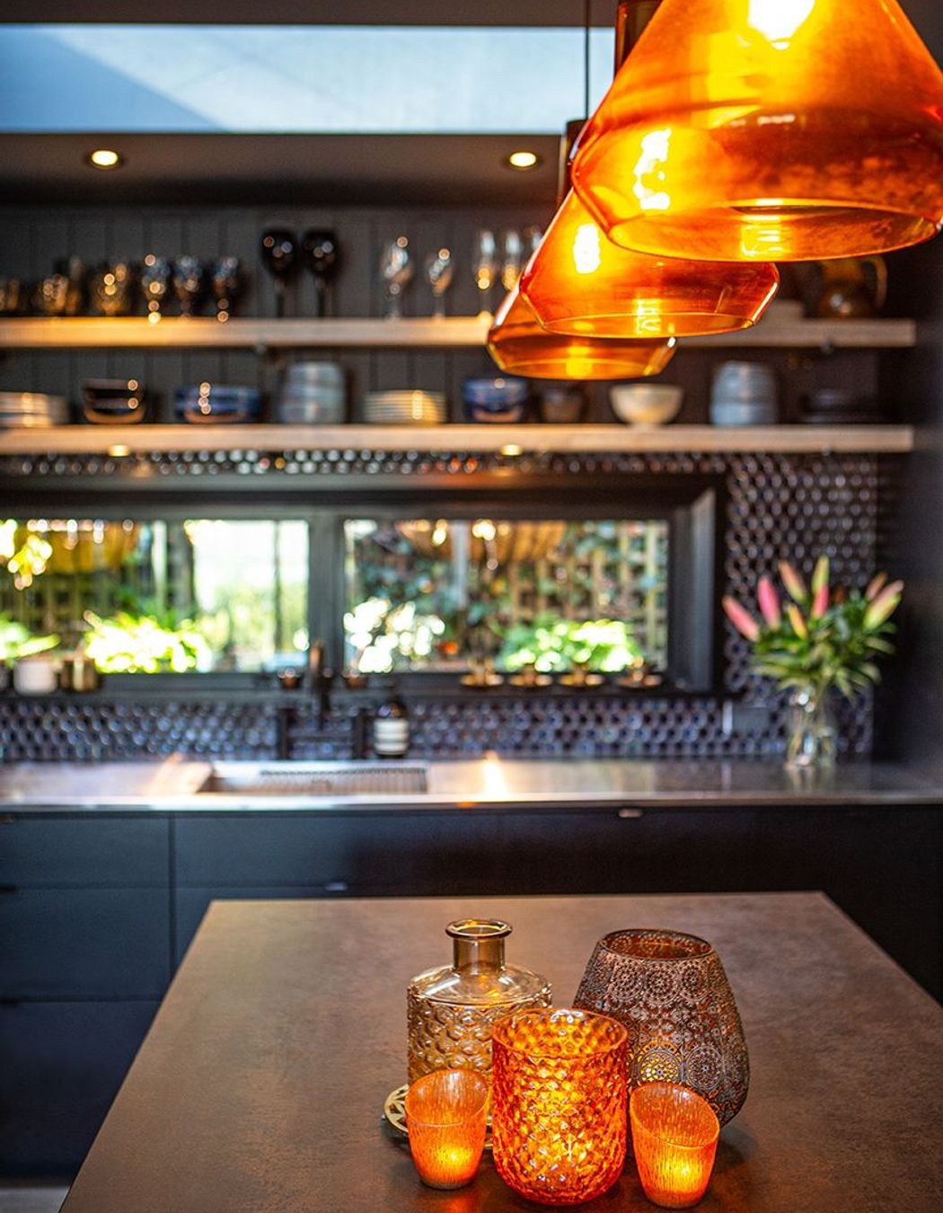 A copper stone benchtop and amber glass sets this kitchen alight.