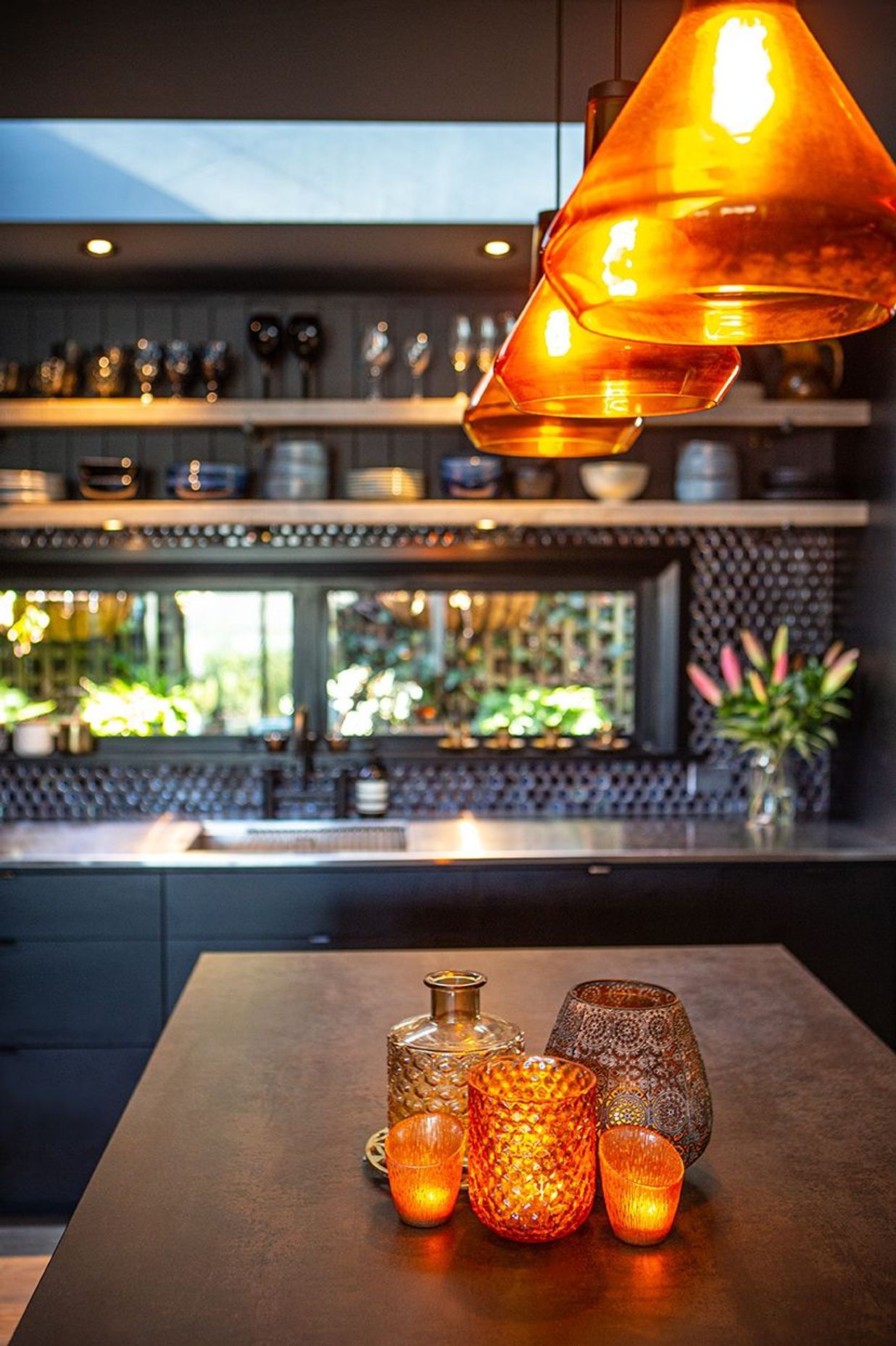A copper stone benchtop and amber glass sets this kitchen alight.