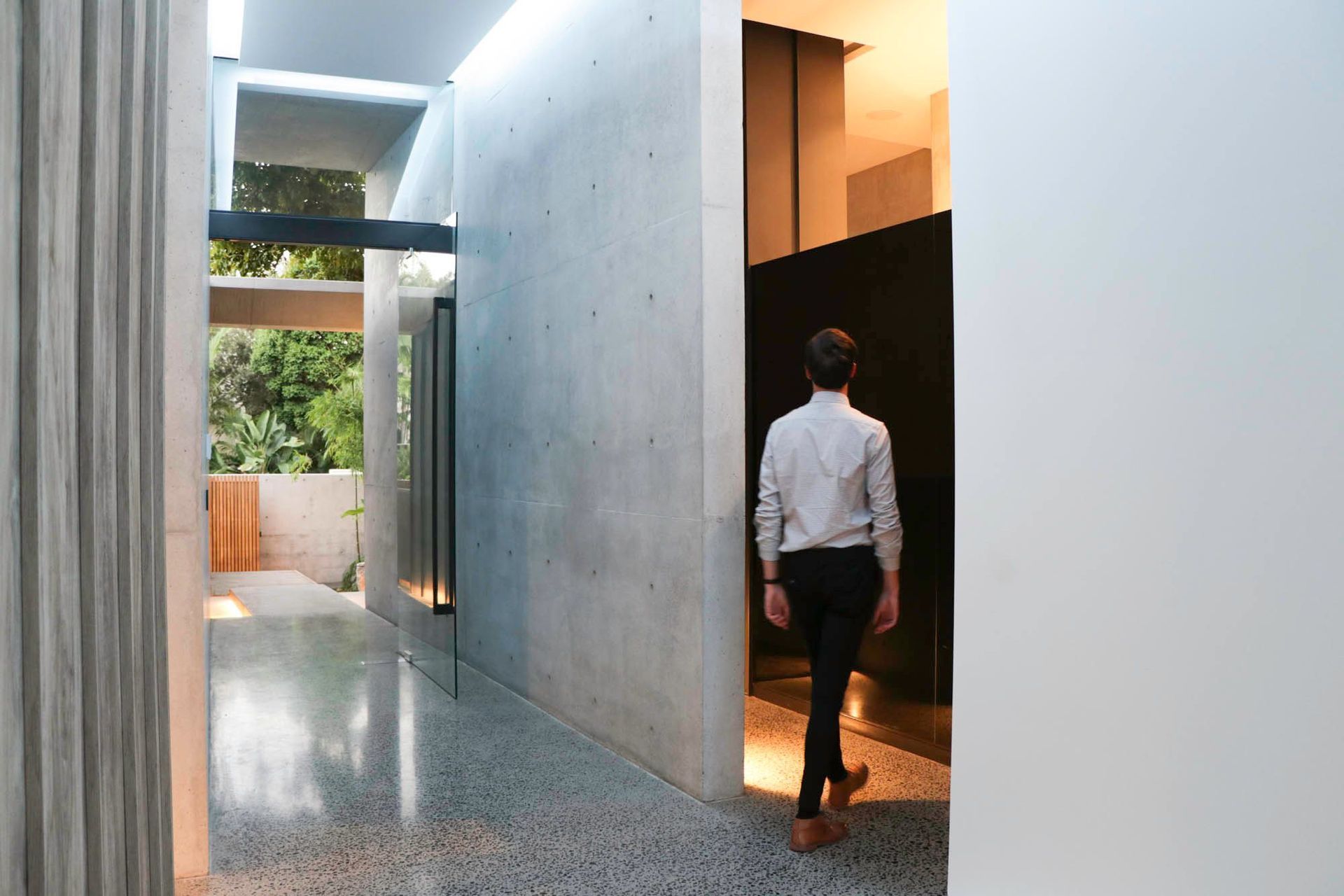 McGovern Residence - Entry. Pivot door opening into the concrete gallery.