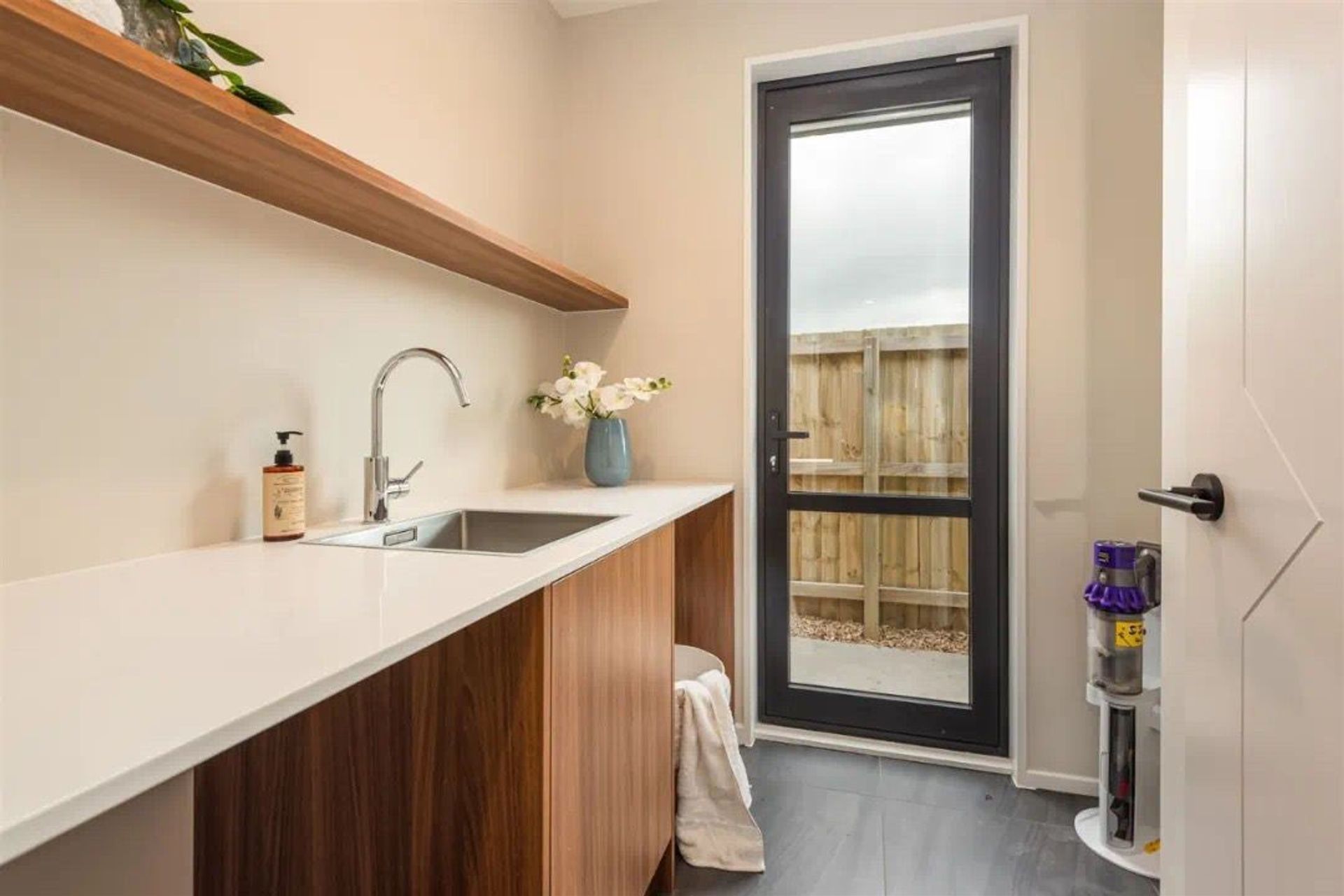 Thicker floating shelf is an alternative option for laundry instead of overhead cabinets. Make the base cabinets the same color as floating shelf is also a great choice.