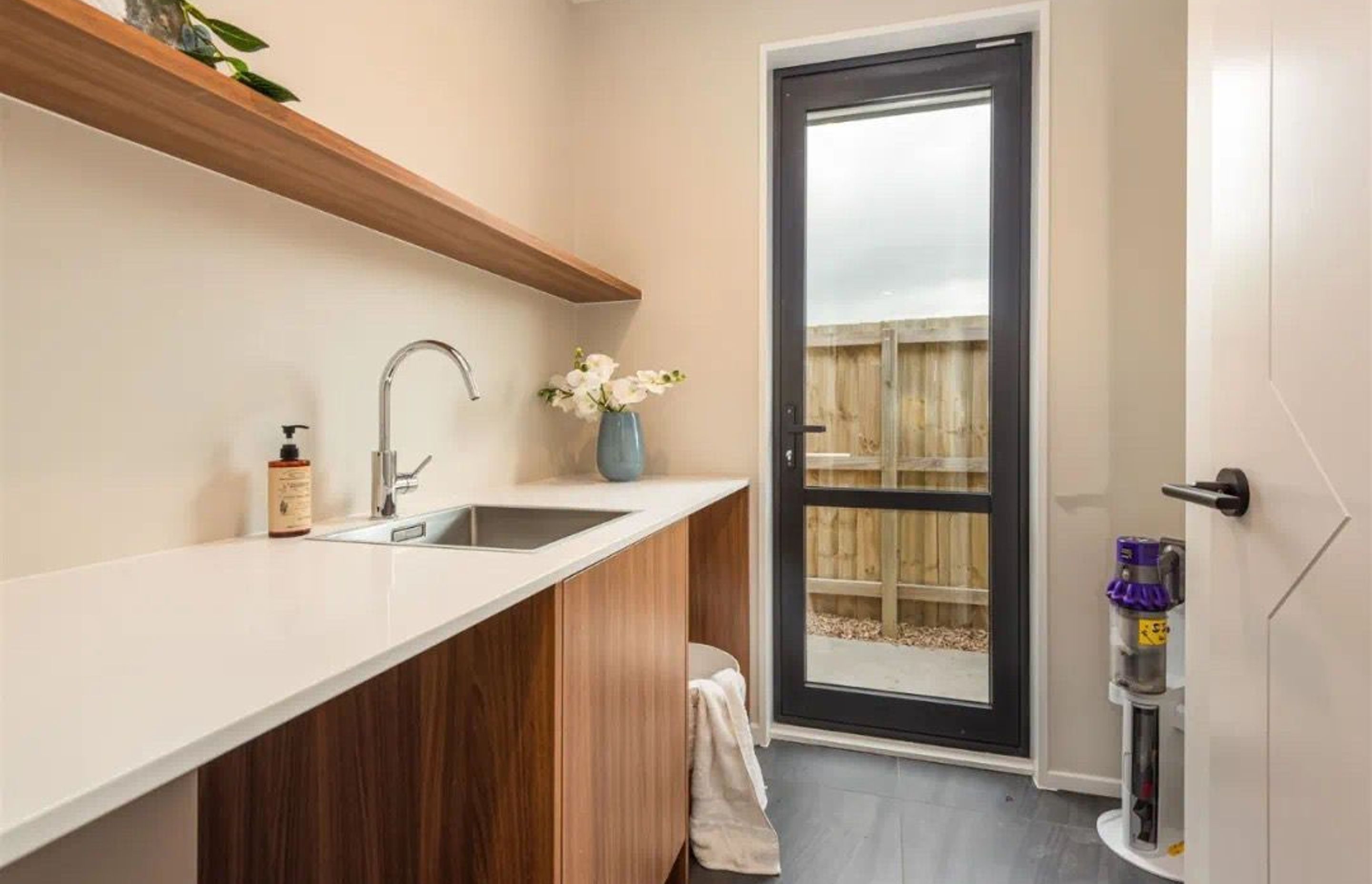 Thicker floating shelf is an alternative option for laundry instead of overhead cabinets. Make the base cabinets the same color as floating shelf is also a great choice.