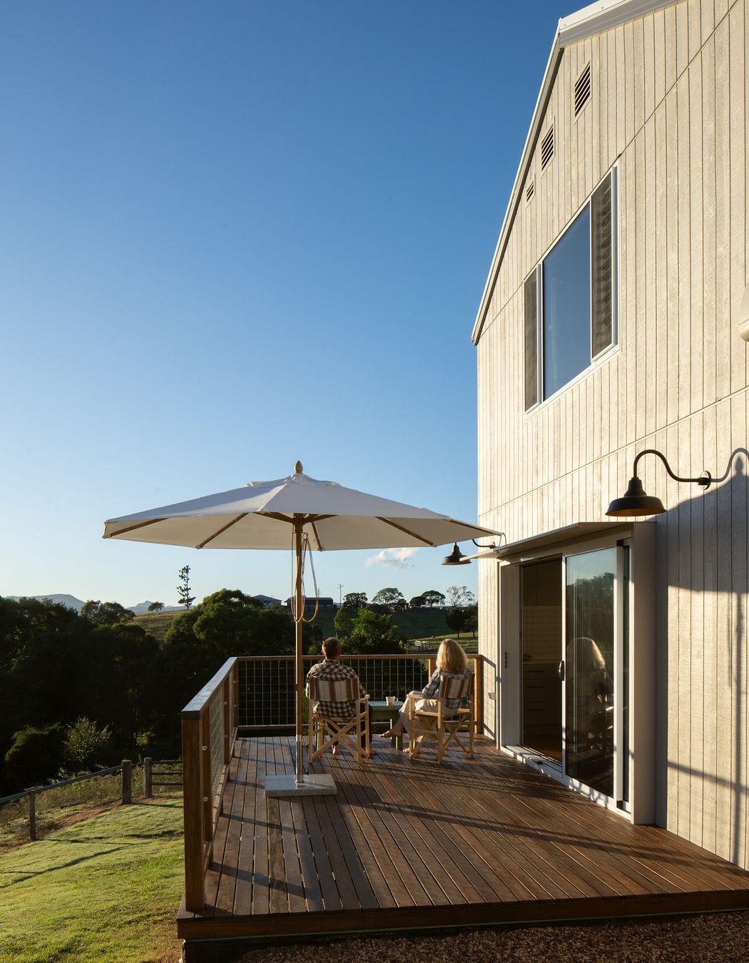 The living spaces flow onto a north facing deck overlooking the yard and yards by a creek below the site.