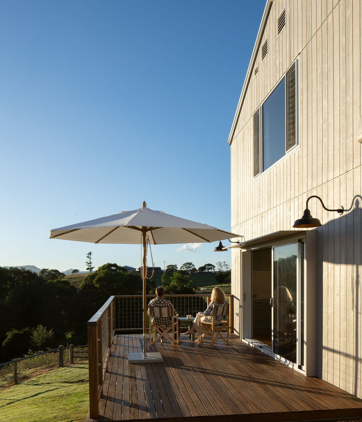 The living spaces flow onto a north facing deck overlooking the yard and yards by a creek below the site.
