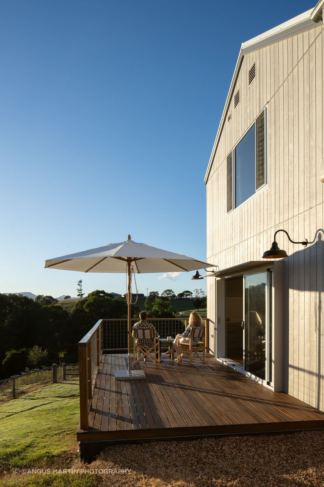 The living spaces flow onto a north facing deck overlooking the yard and yards by a creek below the site.