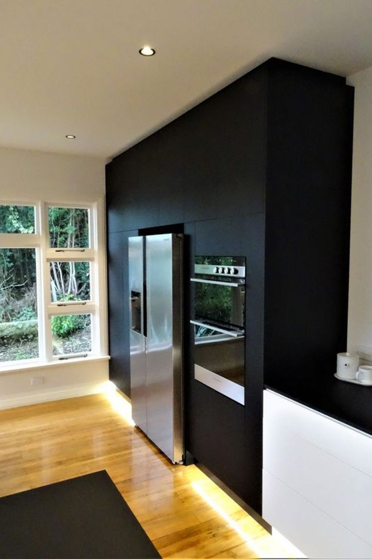 Black kitchen cabinetry ties into the bench top