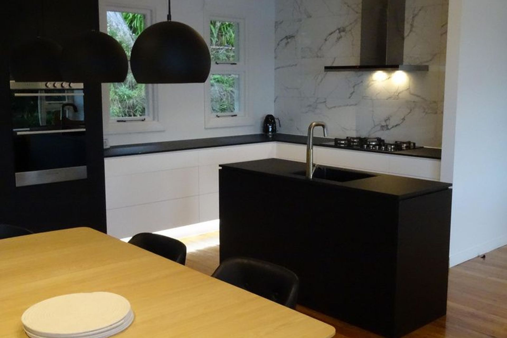 Black kitchen island making a statement in this modern Dunedin kitchen